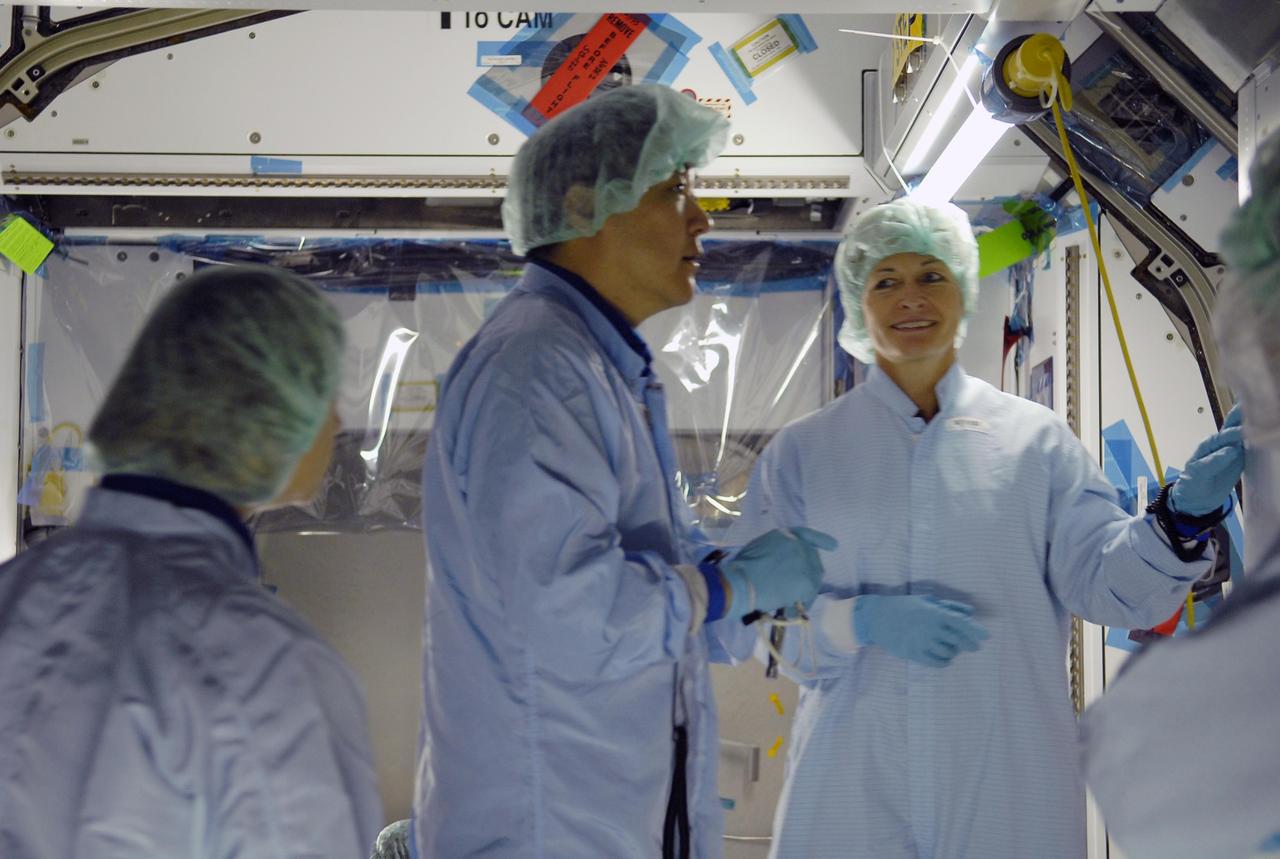 KENNEDY SPACE CENTER, FLA. -- In the Space Station Processing Facility, STS-120 Mission Specialist Daniel Tani (center) learns more about the Node 2, another element to be added to the International Space Station. With him, at right, is astronaut Peggy Whitson, who served on Expedition 5 aboard the space station. During her 6-month stay aboard the space station, Dr. Whitson installed the Mobile Base System, the S1 truss segment, and the P1 truss segment.. He and other crew members are at KSC for equipment familiarization. Tani will be joining the Expedition 15 crew on the space station as flight engineer. Node 2 will provide a passageway between three station science experiment facilities: the U.S. Destiny Laboratory, the Kibo Japanese Experiment Module, and the European Columbus Laboratory. STS-120 is targeted for launch on October 20. Photo credit: NASA/Kim Shiflett