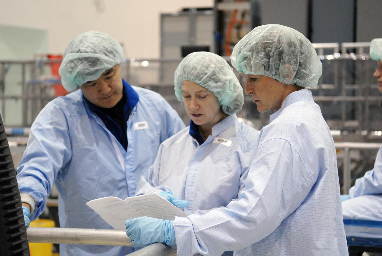 KENNEDY SPACE CENTER, FLA.  --  In the Space Station Processing Facility, STS-120 Mission Specialist Daniel Tani (left) and Commander Pamela Melroy learn some details about the Node 2, another element to be added to the International Space Station. With them, at right, is astronaut Peggy Whitson, who served on Expedition 5 aboard the space station.  During her 6-month stay aboard the space station, Dr. Whitson installed the Mobile Base System, the S1 truss segment, and the P1 truss segment.  Tani, Melroy and other crew members are at KSC for equipment familiarization. Tani will be joining the Expedition 15 crew on the space station as flight engineer. Node 2 will provide a passageway between three station science experiment facilities: the U.S. Destiny Laboratory, the Kibo Japanese Experiment Module, and the European Columbus Laboratory.  STS-120 is targeted for launch on October 20.   Photo credit: NASA/Kim Shiflett