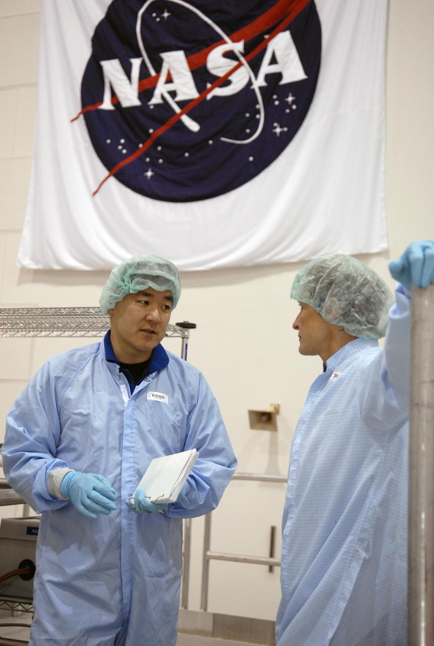 KENNEDY SPACE CENTER, FLA. -- In the Space Station Processing Facility, STS-120 Mission Specialist Daniel Tani (center) talks about his mission and the Node 2, another element to be added to the International Space Station with astronaut Peggy Whitson, at right. Whitson served on Expedition 5 aboard the space station. During her 6-month stay, Dr. Whitson installed the Mobile Base System, the S1 truss segment, and the P1 truss segment. He and other crew members are at KSC for equipment familiarization. Tani will be joining the Expedition 15 crew on the space station as flight engineer. Node 2 will provide a passageway between three station science experiment facilities: the U.S. Destiny Laboratory, the Kibo Japanese Experiment Module, and the European Columbus Laboratory. STS-120 is targeted for launch on October 20. Photo credit: NASA/Kim Shiflett