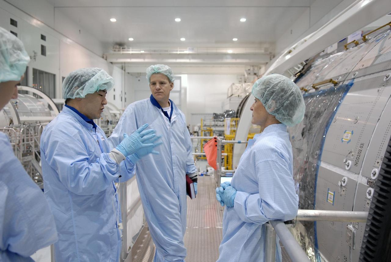 KENNEDY SPACE CENTER, FLA. -- In the Space Station Processing Facility, STS-120 Mission Specialist Daniel Tani (gesturing) explains to Scott Parazynski (center) and astronaut Peggy Whitson what he has learned about the Node 2, another element to be added to the International Space Station. Whitson served on Expedition 5 aboard the space station. Tani and other crew members are at KSC for equipment familiarization. Tani will be joining the Expedition 15 crew on the space station as flight engineer. Node 2 will provide a passageway between three station science experiment facilities: the U.S. Destiny Laboratory, the Kibo Japanese Experiment Module, and the European Columbus Laboratory. STS-120 is targeted for launch on October 20. Photo credit: NASA/Kim Shiflett