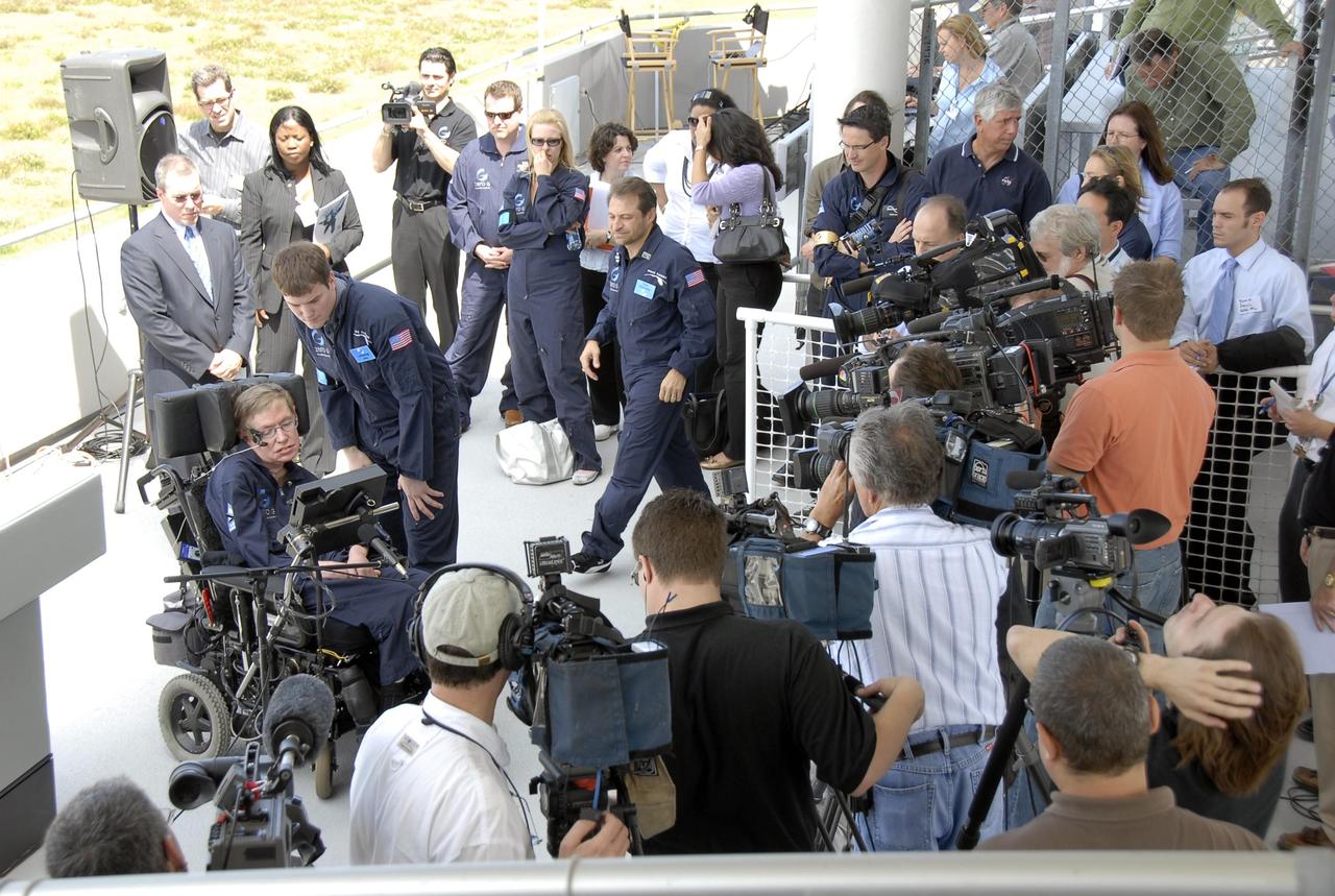 KENNEDY SPACE CENTER, FLA.  --   The media surround noted wheelchair-bound physicist Stephen Hawking after his arrival at the Kennedy Space Center Shuttle Landing Facility for his first zero-gravity flight.  Behind Hawking, at left, is Space Florida president Steve Kohler.  In the center, striding toward Hawking, is Zero Gravity Corp. founder Peter Diamandis. The flight will be aboard a modified Boeing 727 aircraft owned by Zero Gravity, a commercial company licensed to provide the public with weightless flight experiences. Hawking developed amyotrophic lateral sclerosis disease in the 1960s, a type of motor neuron disease which would cost him the loss of almost all neuromuscular control. At the celebration of his 65th birthday on January 8 this year, Hawking announced his plans for a zero-gravity flight to prepare for a sub-orbital space flight in 2009 on Virgin Galactic's space service.  Photo credit: NASA/Kim Shiflett