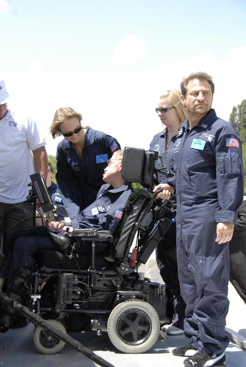 KENNEDY SPACE CENTER, FLA. -- At the Kennedy Space Center Shuttle Landing Facility, noted physicist Stephen Hawking, in the wheelchair, is ready to get onboard a modified Boeing 727 aircraft owned by Zero Gravity Corp. for his first zero-gravity flight.  Zero Gravity Corp. is a commercial company licensed to provide the public with weightless flight experiences.  At right is Peter Diamandis, founder of the Zero Gravity Corp.  Behind Hawking is Nicola O'Brien, a nurse practitioner who is Hawking's aide.  Hawking developed amyotrophic lateral sclerosis disease in the 1960s, a type of motor neuron disease which would cost him the loss of almost all neuromuscular control. At the celebration of his 65th birthday on January 8 this year, Hawking announced his plans for a zero-gravity flight to prepare for a sub-orbital space flight in 2009 on Virgin Galactic's space service.  Photo credit: NASA/Kim Shiflett