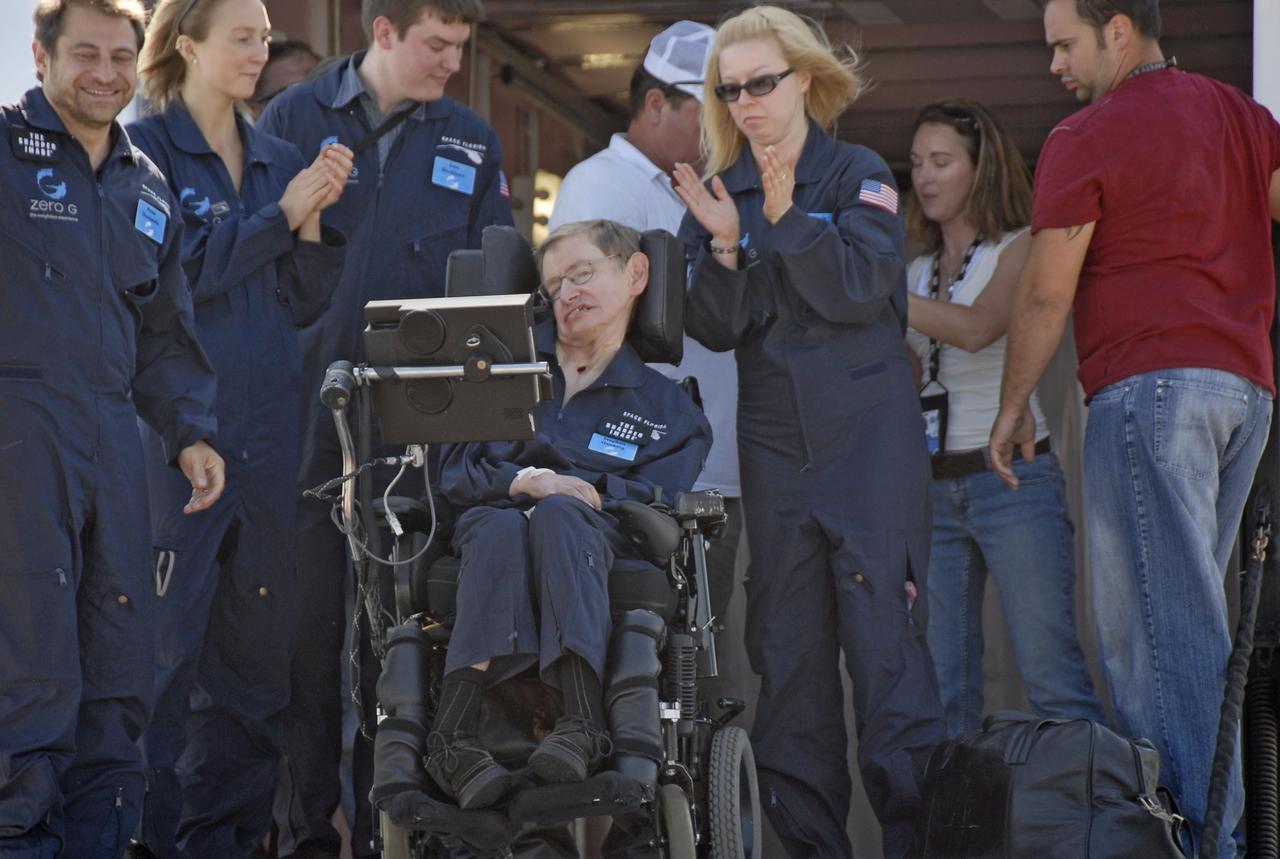 KENNEDY SPACE CENTER, FLA. -- Noted physicist Stephen Hawking (center) returns to the Kennedy Space Center Shuttle Landing Facility after a zero gravity flight. At far left is Peter Diamandis, founder of the Zero Gravity Corp. that provided the flight aboard its modified Boeing 727.  Hawking suffers from amyotrophic lateral sclerosis (also known as Lou Gehrig's disease).  At the celebration of his 65th birthday on January 8 this year, Hawking announced his plans for a zero-gravity flight to prepare for a sub-orbital space flight in 2009 on Virgin Galactic's space service.  Photo credit: NASA/Kim Shiflett