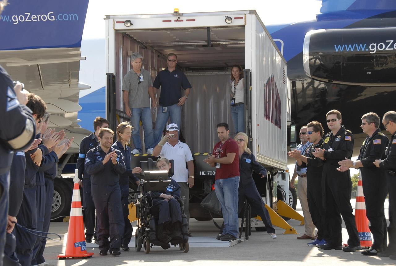 KENNEDY SPACE CENTER, FLA. --  Well-wishers greet noted physicist Stephen Hawking (in the wheelchair) at the Kennedy Space Center Shuttle Landing Facility after a zero gravity flight.  Next to him at left are Peter Diamandis, founder of the Zero Gravity Corp. that provided the flight aboard its modified Boeing 727, and Nicola O'Brien, a nurse practitioner who is Hawking's aide. Hawking suffers from amyotrophic lateral sclerosis (also known as Lou Gehrig's disease). At the celebration of his 65th birthday on January 8 this year, Hawking announced his plans for a zero-gravity flight to prepare for a sub-orbital space flight in 2009 on Virgin Galactic's space service.  Photo credit: NASA/Kim Shiflett