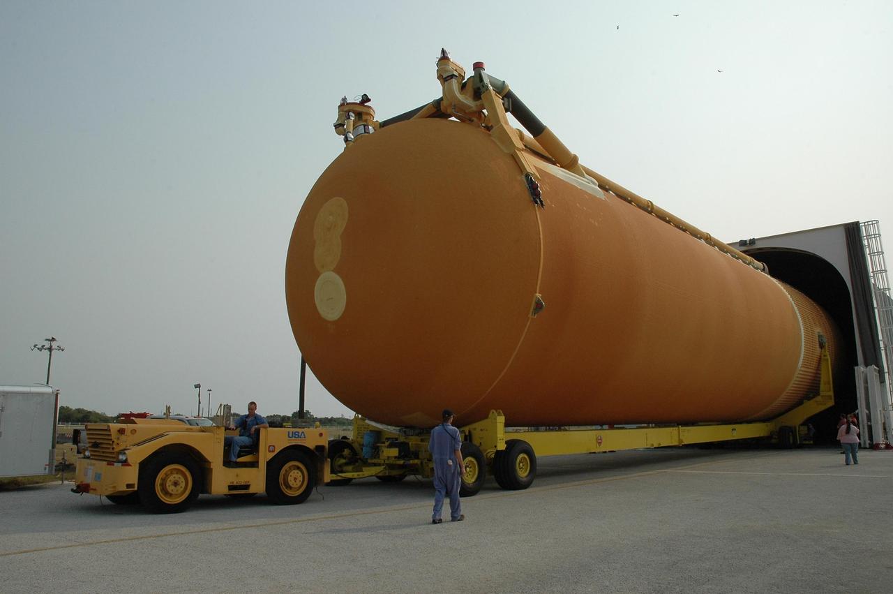 KENNEDY SPACE CENTER, FLA. --   External tank No. 117 is towed out of the Pegasus barge in the turn basin near Kennedy Space Center's Vehicle Assembly Building. ET-117 arrived aboard the barge after its voyage around the Florida Peninsula from the Michoud Assembly Facility near New Orleans. The tank is slated for mission STS-118, which is targeted for launch in early August.  ET-117 will be moved into a checkout cell in high bay 2 of the VAB for processing.  Photo credit: NASA/Jack Pfaller