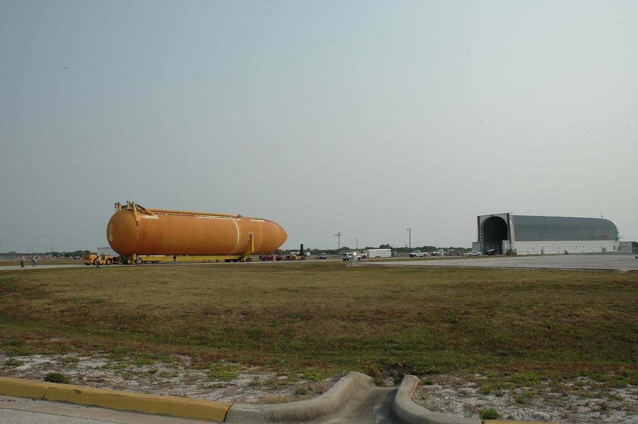 KENNEDY SPACE CENTER, FLA. --   Aboard its transporter, external tank No. 117 moves away from the Pegasus barge, at right, heading for the Vehicle Assembly Building. ET-117 arrived aboard the barge after its voyage around the Florida Peninsula from the Michoud Assembly Facility near New Orleans. The tank is slated for mission STS-118, which is targeted for launch in early August.  ET-117 will be moved into a checkout cell in high bay 2 of the VAB for processing.  Photo credit: NASA/Jack Pfaller