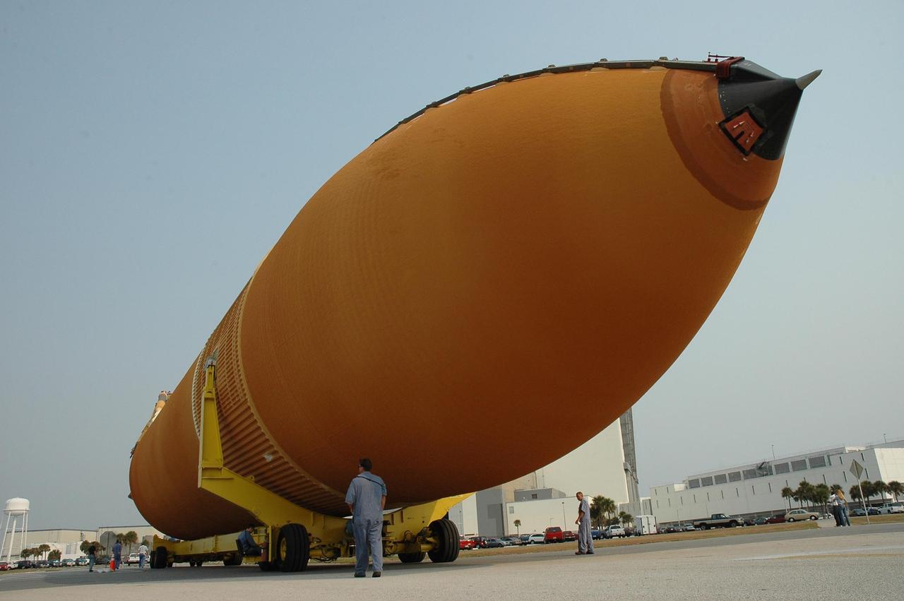 KENNEDY SPACE CENTER, FLA. --   This closeup of external tank No. 117 reveals the enormity of the tank -- 154 feet long, 27.5 feet around and weighing 58,500 pounds -- as it dwarfs the workers behind it.  Offloaded from the Pegasus barge in the nearby turn basin, the tank is heading for the Vehicle Assembly Building.  ET-117 arrived aboard the barge after its voyage around the Florida Peninsula from the Michoud Assembly Facility near New Orleans. The tank is slated for mission STS-118, which is targeted for launch in early August.  ET-117 will be moved into a checkout cell in high bay 2 of the VAB for processing.  Photo credit: NASA/Jack Pfaller