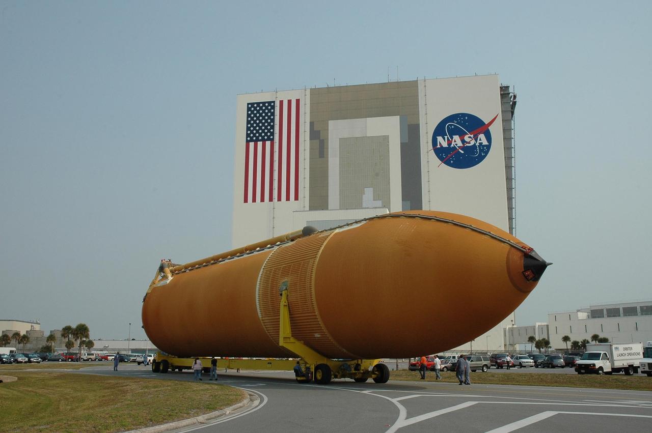 KENNEDY SPACE CENTER, FLA. --   Aboard its transporter, external tank No. 117 maneuvers around the corner as it heads for the Vehicle Assembly Building, seen behind it.  The tank was offloaded from the Pegasus barge in the nearby turn basin.  ET-117 arrived aboard the barge after its voyage around the Florida Peninsula from the Michoud Assembly Facility near New Orleans. The tank is slated for mission STS-118, which is targeted for launch in early August.  ET-117 will be moved into a checkout cell in high bay 2 of the VAB for processing.  Photo credit: NASA/Jack Pfaller