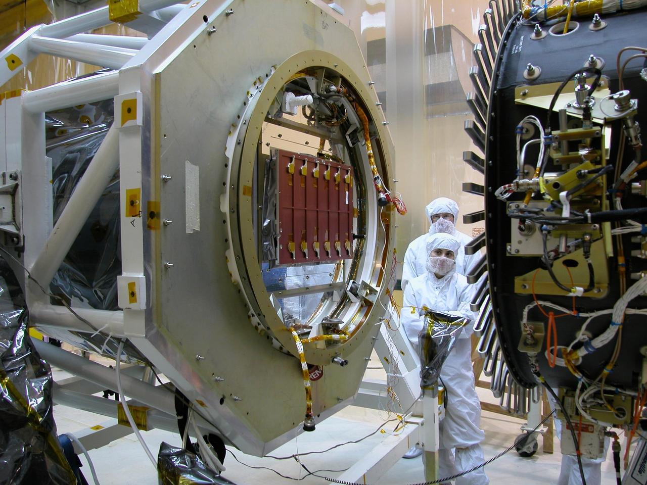 KENNEDY SPACE CENTER, FLA. -- At Vandenberg Air Force Base in California, workers perform a fit check mating the AIM spacecraft to the Orbital Sciences Pegasus XL rocket. Red covers are in place to protect the Cosmic Dust Experiment instrument. AIM, which stands for Aeronomy of Ice in the Mesosphere, is being prepared for integrated testing and a flight simulation. The AIM spacecraft will fly three instruments designed to study polar mesospheric clouds located at the edge of space, 50 miles above the Earth's surface in the coldest part of the planet's atmosphere. The mission's primary goal is to explain why these clouds form and what has caused them to become brighter and more numerous and appear at lower latitudes in recent years. AIM's results will provide the basis for the study of long-term variability in the mesospheric climate and its relationship to global climate change. Launch from the Pegasus XL rocket is scheduled for April 25.