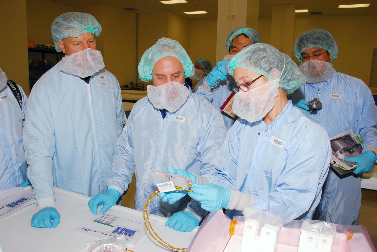 KENNEDY SPACE CENTER, FLA. -- During a bench review in the Space Station Processing Facility, astronauts Tim Kopra (left) and Garrett Reisman (center) get a close look at hardware they will be taking into and using in orbit. Reisman is slated to join Expedition 16 aboard the International Space Station in 2008, flying on mission STS-123; Kopra is his backup. Behind them is Koichi Wakata, with the Japanese Aerospace and Exploration Agency, who will join the Expedition 18 crew, flying on mission STS-126. Photo credit: NASA/George Shelton