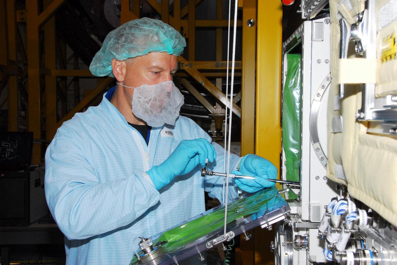 KENNEDY SPACE CENTER, FLA. -- During a bench review in the Space Station Processing Facility, astronaut Tim Kopra gets hands-on experience on hardware he could be using in orbit. Kopra is backup for Garrett Reisman, who will join the Expedition 16 crew on the International Space Station in 2008. Reisman will fly on mission STS-123 to the station. Photo credit: NASA/George Shelton