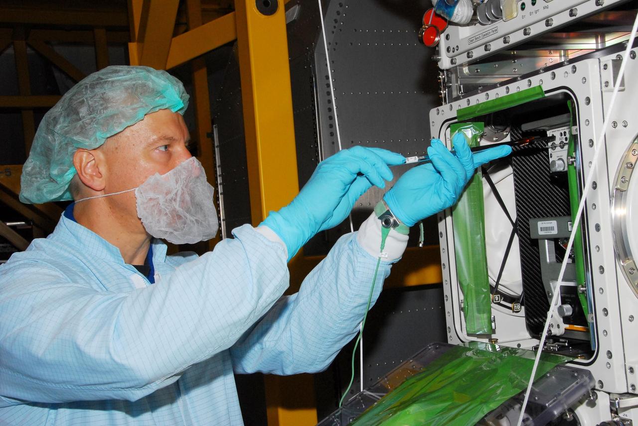 KENNEDY SPACE CENTER, FLA. -- During a bench review in the Space Station Processing Facility, astronaut Tim Kopra gets hands-on experience on hardware he could be using in orbit. Kopra is backup for Garrett Reisman, who will join the Expedition 16 crew on the International Space Station in 2008. Reisman will fly on mission STS-123 to the station. Photo credit: NASA/George Shelton