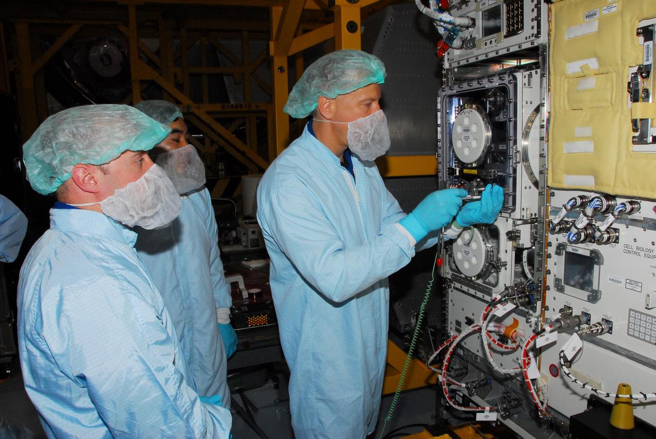 KENNEDY SPACE CENTER, FLA. -- During a bench review in the Space Station Processing Facility, astronauts get a close look at hardware they will be taking into and using in orbit. At left are Garrett Reisman (foreground) and Koichi Wakata; practicing with the equipment is Tim Kopra. Reisman will join the Expedition 16 crew on the International Space Station in 2008, flying on mission STS-123. Wakata, with the Japanese Aerospace and Exploration Agency, will join the Expedition 18 crew in 2008, flying on mission STS-126. Kopra is backup for Reisman. Photo credit: NASA/George Shelton