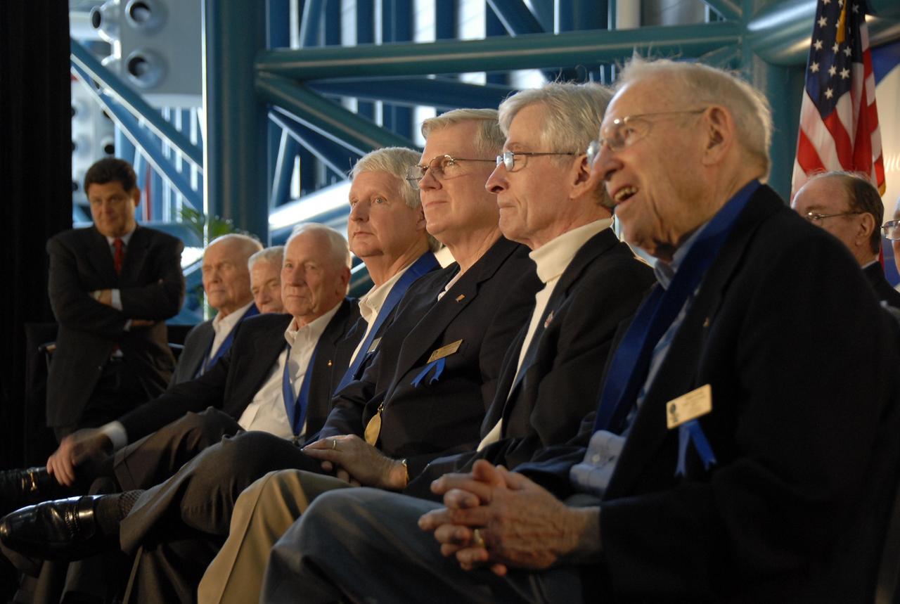 KENNEDY SPACE CENTER, FLA. --  At the U.S. Astronaut Hall of Fame induction ceremony, new and former inductees are seated on the dais.  In the front row, from left, are John Glenn, Scott Carpenter, Al Worden, Steven Hawley, Michael Coats, John Young, Jim Lovell and Ed Mitchell. At far left is John Zarrella, CNN's Miami Bureau Chief, who moderated.  The May 5 induction added space shuttle commanders Michael L. Coats, Steven A. Hawley and Jeffrey A. Hoffman to the Hall of Fame.  They grow the number of space explorers enshrined in the Hall of Fame to 66.  The ceremony was held at the Kennedy Space Center's Apollo/Saturn V Center.  Photo credit: NASA/Kim Shiflett