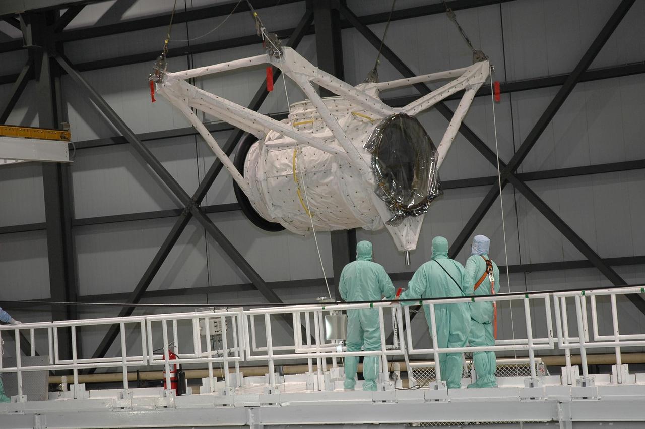 KENNEDY SPACE CENTER, FLA. -- In Orbiter Processing Facility bay 2 at NASA's Kennedy Space Center, an overhead crane moves the crew airlock module toward Endeavour. It will be installed in Endeavour's payload bay. The airlock is located in the middeck. The airlock and airlock hatches permit flight crew members to transfer from the middeck crew compartment into the payload bay for extravehicular activities in their space suits without depressurizing the orbiter crew cabin. The airlock is sized to accommodate two fully suited flight crew members simultaneously. Endeavour is targeted for flight on Aug. 9 on mission STS-118 to the International Space Station. Photo credit: NASA/Jack Pfaller