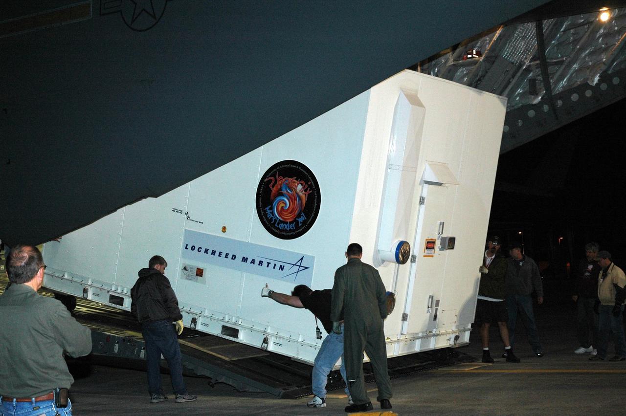KENNEDY SPACE CENTER, FLA. --  On Kennedy Space Center's Shuttle Landing Facility, workers oversee the offloading of the crated Phoenix spacecraft inside the cargo hold of a U.S. Air Force C-17 Globemaster III.  The crate will be transported to the Payload Hazardous Servicing Facility. The Phoenix mission is the first project in NASA's first openly competed program of Mars Scout missions. Phoenix will land in icy soils near the north polar permanent ice cap of Mars and explore the history of the water in these soils and any associated rocks, while monitoring polar climate. Landing is planned in May 2008 on arctic ground where a mission currently in orbit, Mars Odyssey, has detected high concentrations of ice just beneath the top layer of soil. It will serve as NASA's first exploration of a potential modern habitat on Mars and open the door to a renewed search for carbon-bearing compounds, last attempted with NASA’s Viking missions in the 1970s. A stereo color camera and a weather station will study the surrounding environment while the other instruments check excavated soil samples for water, organic chemicals and conditions that could indicate whether the site was ever hospitable to life. Microscopes can reveal features as small as one one-thousandth the width of a human hair. Launch of Phoenix aboard a Delta II rocket is targeted for Aug. 3 from Cape Canaveral Air Force Station in Florida.  Photo credit: NASA/Charisse Nahser