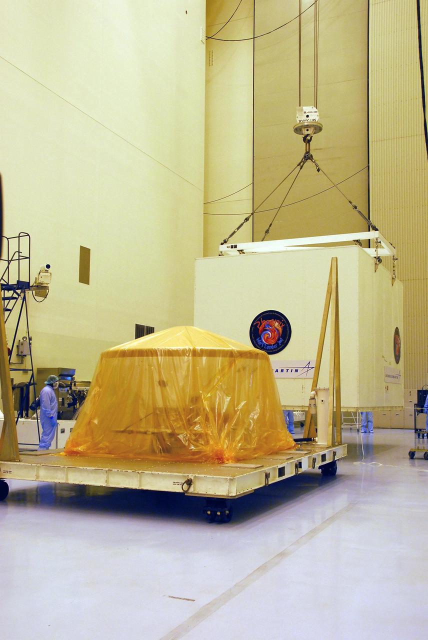 KENNEDY SPACE CENTER, FLA. --  In the Payload Hazardous Servicing Facility at Kennedy Space Center, a crane lifts the shipping crate from around the Phoenix spacecraft.  The spacecraft arrived May 7 via a U.S. Air Force C-17 Globemaster III at the Shuttle Landing Facility. The Phoenix mission is the first project in NASA's first openly competed program of Mars Scout missions. Phoenix will land in icy soils near the north polar permanent ice cap of Mars and explore the history of the water in these soils and any associated rocks, while monitoring polar climate. Landing is planned in May 2008 on arctic ground where a mission currently in orbit, Mars Odyssey, has detected high concentrations of ice just beneath the top layer of soil. It will serve as NASA's first exploration of a potential modern habitat on Mars and open the door to a renewed search for carbon-bearing compounds, last attempted with NASA’s Viking missions in the 1970s. A stereo color camera and a weather station will study the surrounding environment while the other instruments check excavated soil samples for water, organic chemicals and conditions that could indicate whether the site was ever hospitable to life. Microscopes can reveal features as small as one one-thousandth the width of a human hair. Launch of Phoenix aboard a Delta II rocket is targeted for Aug. 3 from Cape Canaveral Air Force Station in Florida.  Photo credit: NASA/George Shelton
