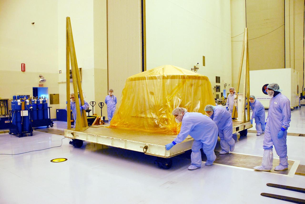 KENNEDY SPACE CENTER, FLA. --  In the Payload Hazardous Servicing Facility at Kennedy Space Center, workers move the platform with the Phoenix spacecraft into another room. The Phoenix mission is the first project in NASA's first openly competed program of Mars Scout missions. Phoenix will land in icy soils near the north polar permanent ice cap of Mars and explore the history of the water in these soils and any associated rocks, while monitoring polar climate. Landing is planned in May 2008 on arctic ground where a mission currently in orbit, Mars Odyssey, has detected high concentrations of ice just beneath the top layer of soil. It will serve as NASA's first exploration of a potential modern habitat on Mars and open the door to a renewed search for carbon-bearing compounds, last attempted with NASA’s Viking missions in the 1970s. A stereo color camera and a weather station will study the surrounding environment while the other instruments check excavated soil samples for water, organic chemicals and conditions that could indicate whether the site was ever hospitable to life. Microscopes can reveal features as small as one one-thousandth the width of a human hair. Launch of Phoenix aboard a Delta II rocket is targeted for Aug. 3 from Cape Canaveral Air Force Station in Florida.  Photo credit: NASA/George Shelton
