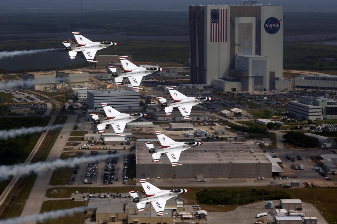 KENNEDY SPACE CENTER, FLA. --   U.S. Air Force Thunderbird F-16 jets fly in formation past the Vehicle Assembly Building in the Industrial Area of Kennedy Space Center.  The purpose of the flyover was to photograph the planes at KSC for promotional purposes. The Kennedy Space Center Visitor Complex will host the inaugural World Space Expo from Nov. 3 to 11, featuring an aerial salute by the Thunderbirds on its opening weekend. The Expo will create one of the largest displays of space artifacts, hardware and personalities ever assembled in one location with the objective to inspire, educate and engage the public by highlighting the achievements and benefits of space exploration. Photo credit: U.S. Air Force photograph by TSgt Justin D. Pyle