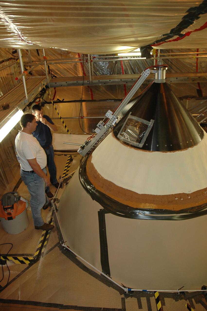 KENNEDY SPACE CENTER, FLA. --  In NASA Kennedy Space Center's Vehicle Assembly Building, technicians  observe the sander used to repair hail damage on Atlantis' nose cone.  In late February, Atlantis' external tank received hail damage during a severe thunderstorm that passed through the Kennedy Space Center Launch Complex 39 area. The hail caused visible divots in the giant tank's foam insulation as well as minor surface damage to about 26 heat shield tiles on the shuttle's left wing.  The launch of Space Shuttle Atlantis on mission STS-117 now is targeted for June 8.  Photo credit: NASA/Jack Pfaller