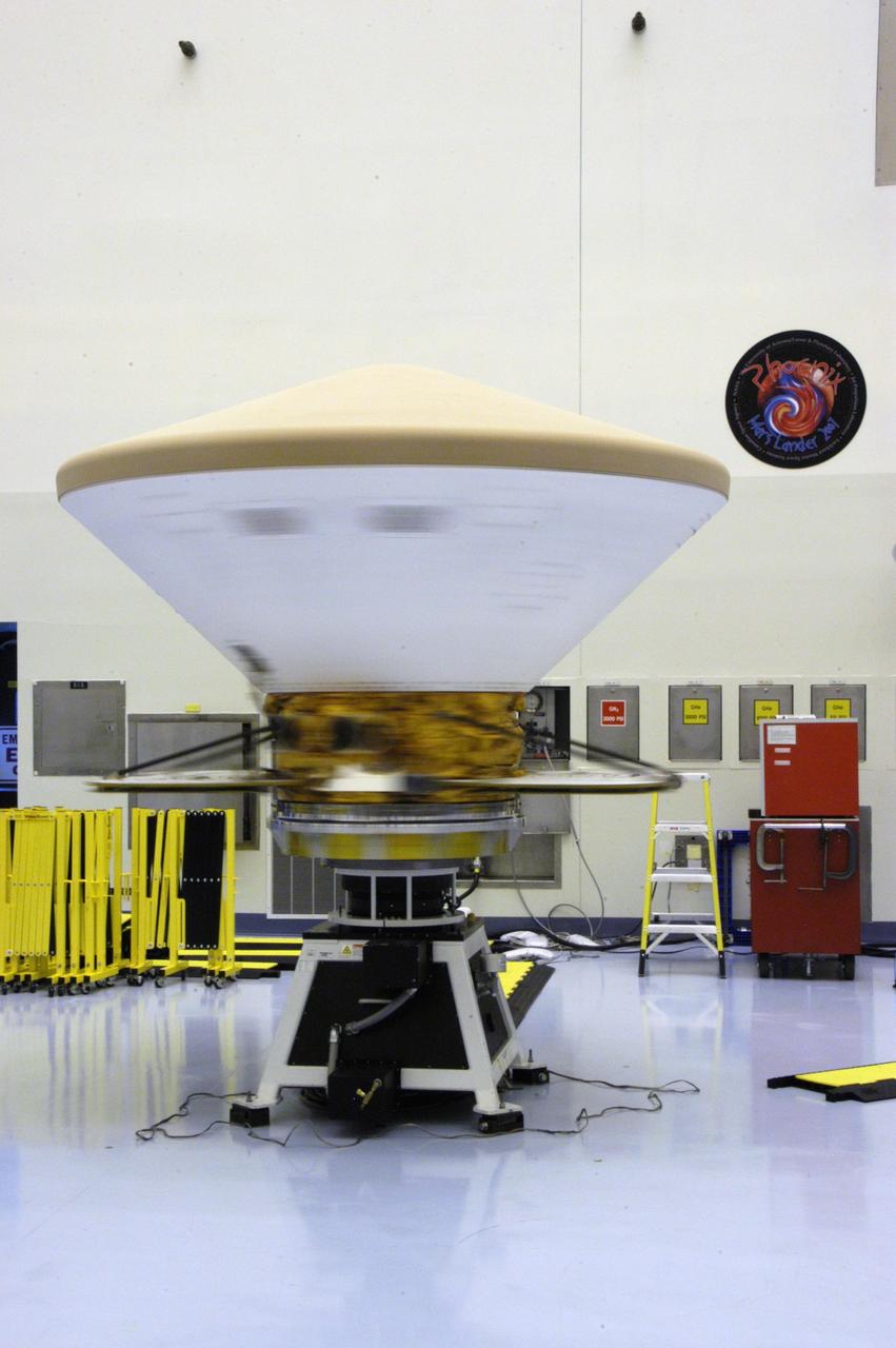 KENNEDY SPACE CENTER, FLA. --  In the Payload Hazardous Servicing Facility, the Phoenix Mars Lander spacecraft undergoes spin testing. The Phoenix mission is the first project in NASA's first openly competed program of Mars Scout missions. Phoenix will land in icy soils near the north polar permanent ice cap of Mars and explore the history of the water in these soils and any associated rocks, while monitoring polar climate. Landing is planned in May 2008 on arctic ground where a mission currently in orbit, Mars Odyssey, has detected high concentrations of ice just beneath the top layer of soil. It will serve as NASA's first exploration of a potential modern habitat on Mars and open the door to a renewed search for carbon-bearing compounds, last attempted with NASA's Viking missions in the 1970s. A stereo color camera and a weather station will study the surrounding environment while the other instruments check excavated soil samples for water, organic chemicals and conditions that could indicate whether the site was ever hospitable to life. Microscopes can reveal features as small as one one-thousandth the width of a human hair. Launch of Phoenix aboard a Delta II rocket is targeted for Aug. 3 from Cape Canaveral Air Force Station in Florida. Photo credit: NASA/George Shelton
