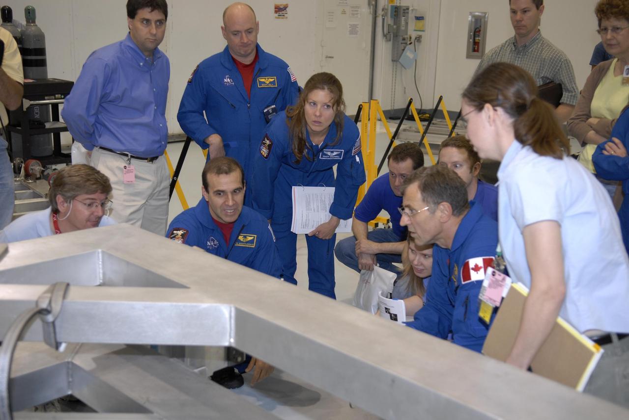KENNEDY SPACE CENTER, FLA. --The STS-118 crew members look over parts of the mission payload, the S5 integrated truss, in the Space Station Processing Facility during crew equipment interface test activities. Seen here are (standing) Commander Scott Kelly and Mission Specialist Tracy Caldwell, and (foreground) Mission Specialists Richard Mastracchio and Dr. Dafydd Williams. Other crew members are Pilot Charles Hobaugh and Mission Specialists Barbara Morgan and Benjamin Drew. Williams is with the Canadian Space Agency. The STS-118 mission will be delivering the third starboard truss segment, the ITS S5, to the International Space Station, and a SPACEHAB Single Cargo module with supplies and equipment. Launch aboard Space Shuttle Endeavour is targeted for August. Photo credit: NASA/Kim Shiflett