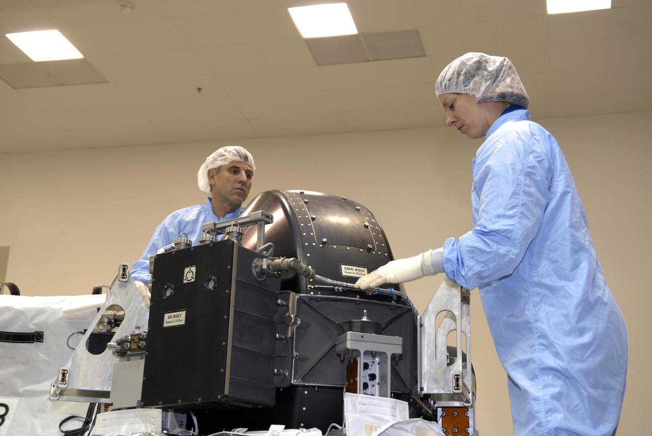 KENNEDY SPACE CENTER, FLA. -- The STS-118 crew members look over parts of the mission payload, the control moment gyroscope, at SPACEHAB during crew equipment interface test activities. Seen here are Mission Specialists Dr. Dafydd Williams and Tracy Caldwell. The crew comprises Commander Scott Kelly, Pilot Charles Hobaugh, and Mission Specialists Williams, Barbara Morgan, Richard Mastracchio, Caldwell and Benjamin Drew. Williams is with the Canadian Space Agency. The STS-118 mission will be delivering the third starboard truss segment, the ITS S5, to the International Space Station, and a SPACEHAB Single Cargo module with supplies and equipment. Launch aboard Space Shuttle Endeavour is targeted for August. Photo credit: NASA/Kim Shiflett