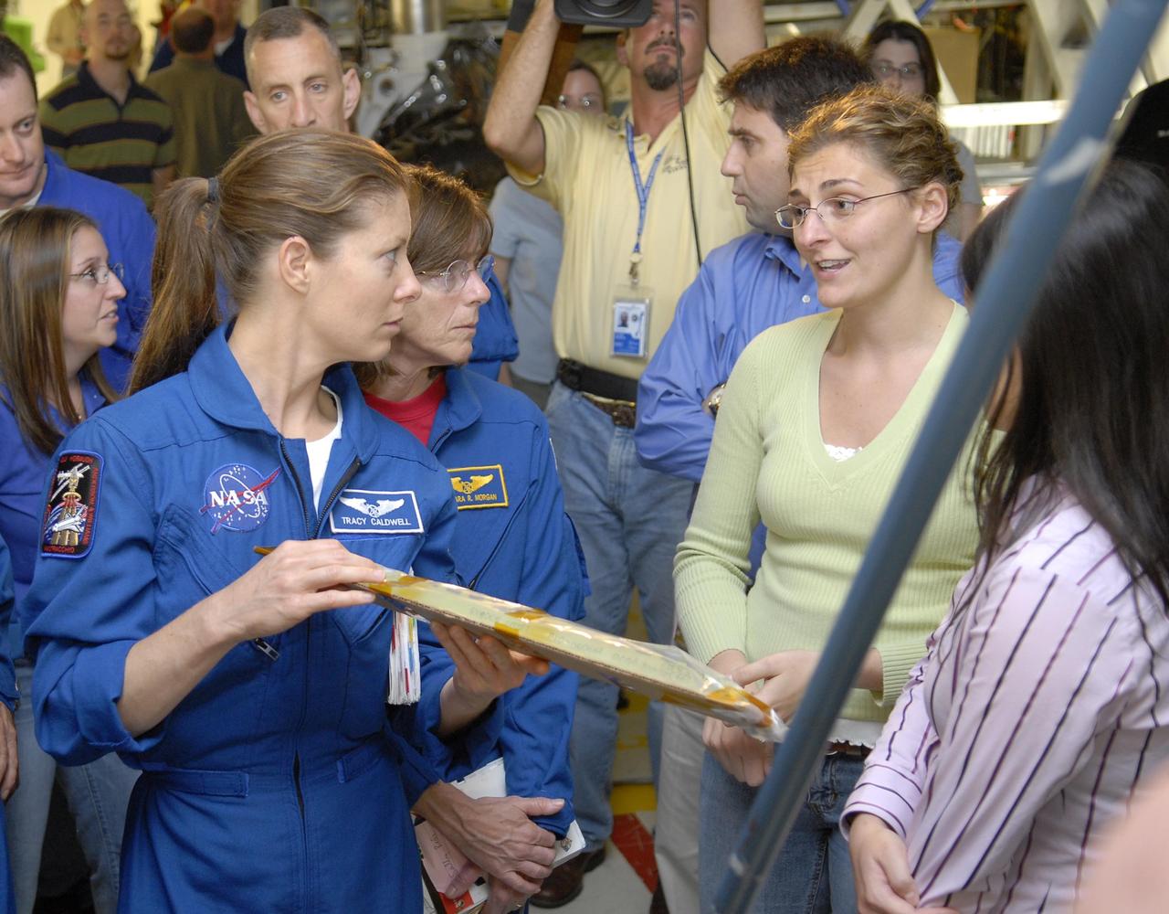 KENNEDY SPACE CENTER, FLA. --    During crew equipment interface test activities, members of the STS-118 crew address a piece of equipment with a worker in Orbiter Processing Facility bay 2.  Mission Specialist Tracy Caldwell holds the package; next to her is Mission Specialist Barbara Morgan.  Behind Caldwell is Pilot Charles Hobaugh.  The STS-118 mission will be delivering the third starboard truss segment, the ITS S5, to the International Space Station, as well as the SPACEHAB single cargo module filled with supplies and equipment.  Launch aboard Space Shuttle Endeavour is targeted for Aug. 9.   Photo credit: NASA/Kim Shiflett