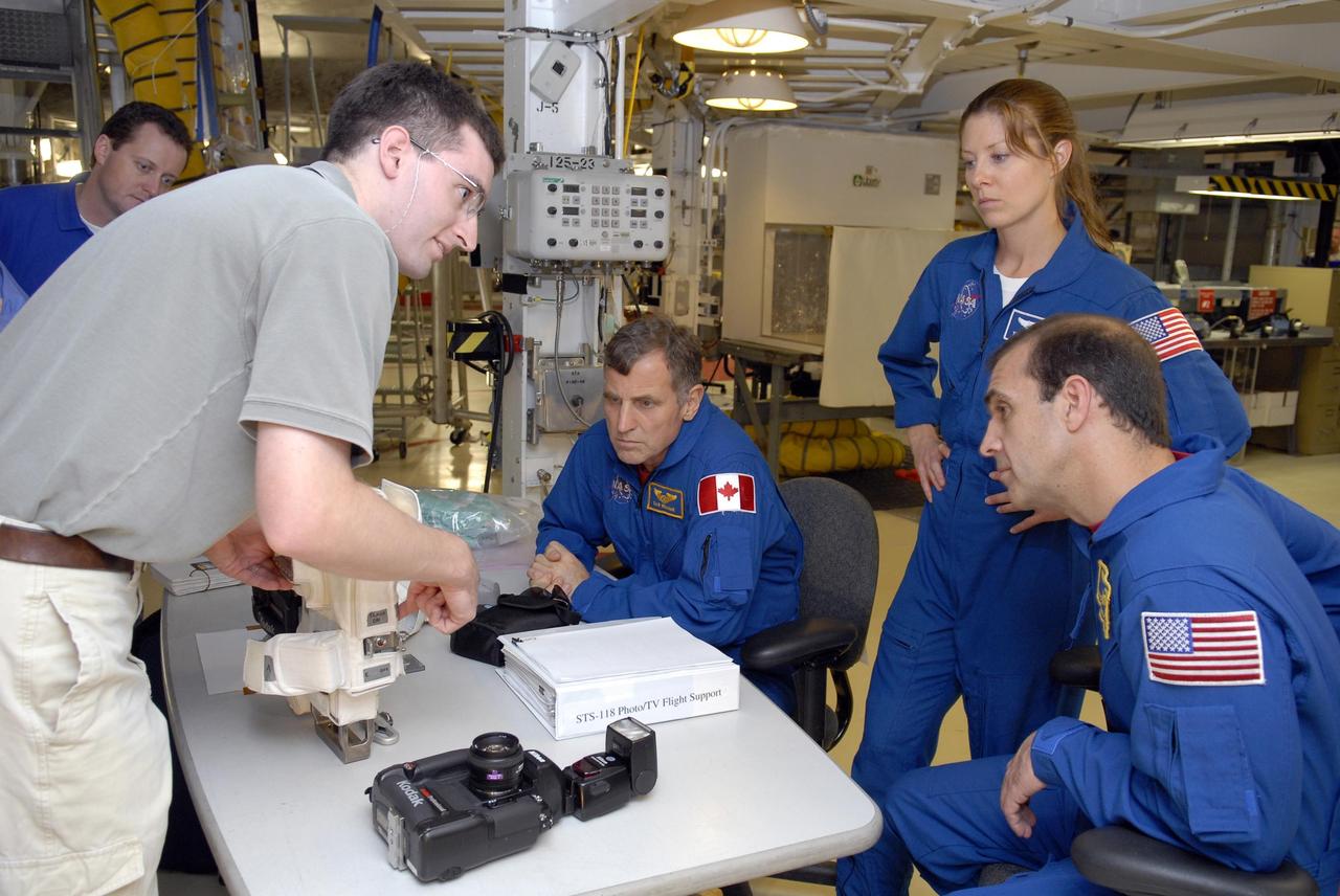 KENNEDY SPACE CENTER, FLA. -- In Orbiter Processing Facility bay 2, during crew equipment interface test activities, STS-118 Mission Specialists Dr. Dafydd Williams, Tracy Caldwell and Richard Mastrocchio get instructions on using photo equipment for their flight. The STS-118 mission will be delivering the third starboard truss segment, the ITS S5, to the International Space Station, as well as the SPACEHAB single cargo module filled with supplies and equipment.  Launch aboard Space Shuttle Endeavour is targeted for Aug. 9.   Photo credit: NASA/Kim Shiflett