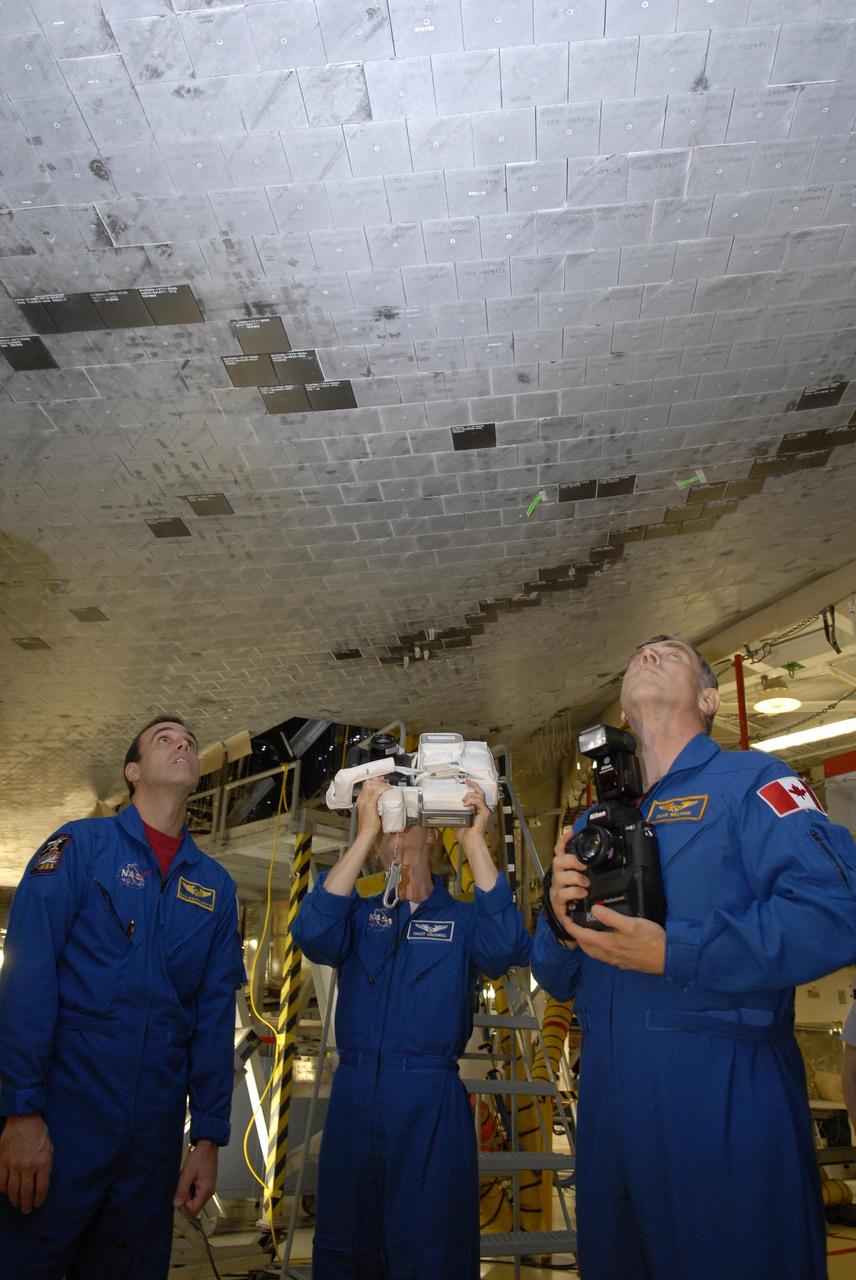 KENNEDY SPACE CENTER, FLA. --  In Orbiter Processing Facility bay 2, during crew equipment interface test activities, STS-118 Mission Specialists Dr. Dafydd Williams, Tracy Caldwell and Richard Mastrocchio are getting practice photographing the underside of the orbiter Endeavour, which they may do on the flight. The STS-118 mission will be delivering the third starboard truss segment, the ITS S5, to the International Space Station, as well as the SPACEHAB single cargo module filled with supplies and equipment.  Launch aboard Space Shuttle Endeavour is targeted for Aug. 9.   Photo credit: NASA/Kim Shiflett