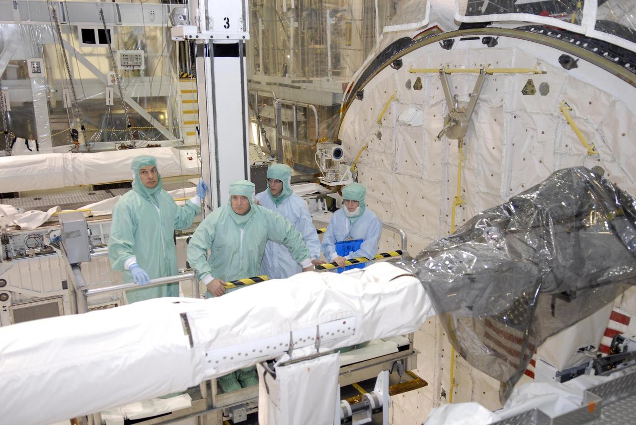 KENNEDY SPACE CENTER, FLA. --   In Orbiter Processing Facility bay 2, during crew equipment interface test activities, STS-118 crew members get a close look at the orbiter boom sensor system in Endeavour's payload bay.  At center are Commander Scott Kelly and Mission Specialist Barbara Morgan.  The STS-118 mission will be delivering the third starboard truss segment, the ITS S5, to the International Space Station, as well as the SPACEHAB single cargo module filled with supplies and equipment.  Launch aboard Space Shuttle Endeavour is targeted for Aug. 9.   Photo credit: NASA/Kim Shiflett