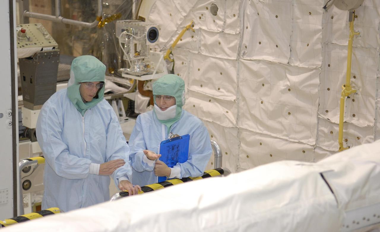 KENNEDY SPACE CENTER, FLA. --    In Endeavour's payload bay in Orbiter Processing Facility bay 2, STS-118 Mission Specialist Barbara Morgan gets some details about the orbiter boom sensor system in front of her.  She and other crew members are at KSC for crew equipment interface test activities. The STS-118 mission will be delivering the third starboard truss segment, the ITS S5, to the International Space Station, as well as the SPACEHAB single cargo module filled with supplies and equipment.  Launch aboard Space Shuttle Endeavour is targeted for Aug. 9.   Photo credit: NASA/Kim Shiflett
