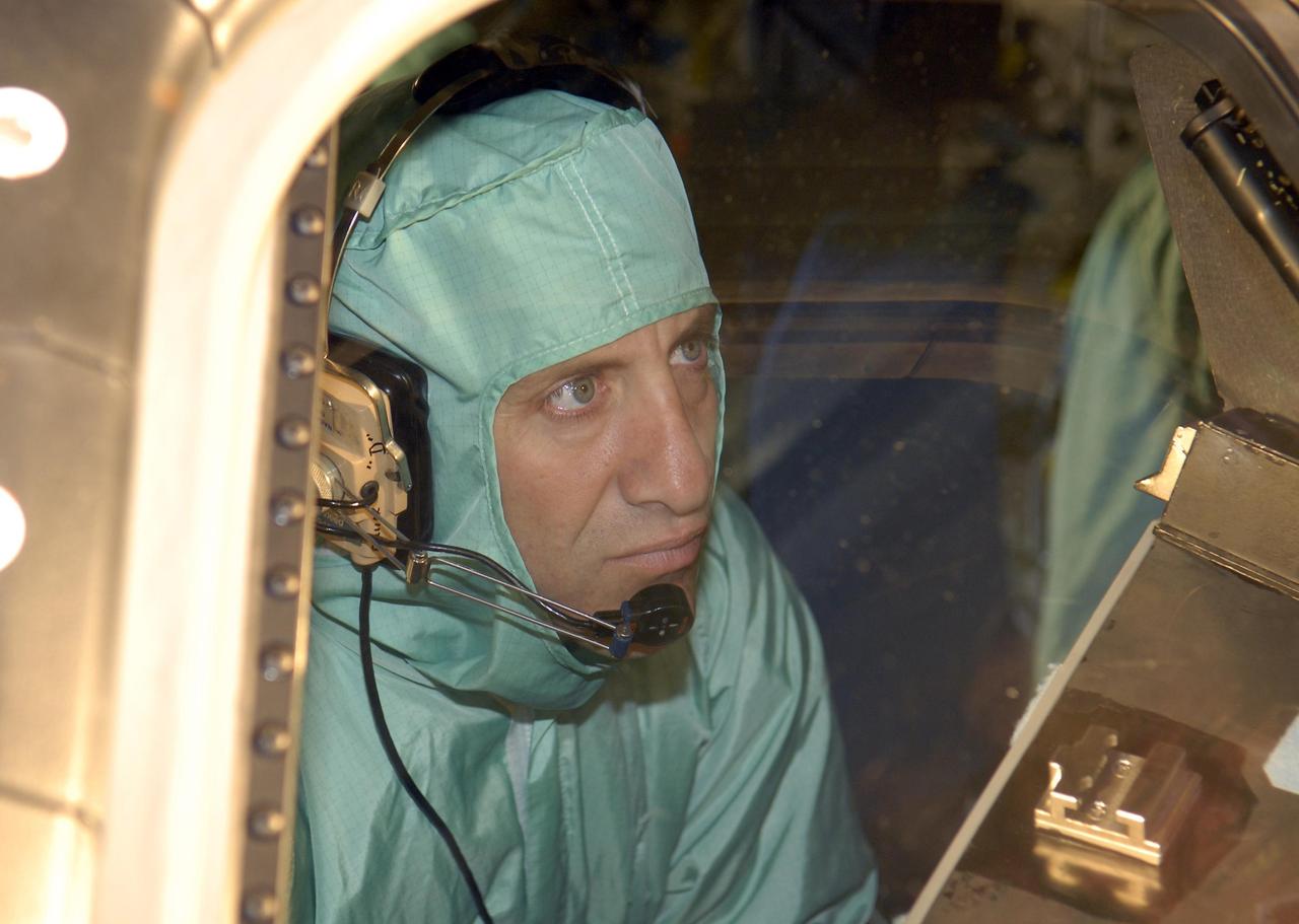 KENNEDY SPACE CENTER, FLA. --   During crew equipment interface test activities at KSC, STS-118 Pilot Charles Hobaugh checks the cockpit windshield of orbiter Endeavour, which is in Orbiter Processing Facility bay 3. The STS-118 mission will be delivering the third starboard truss segment, the ITS S5, to the International Space Station, as well as the SPACEHAB single cargo module filled with supplies and equipment.  Launch aboard Space Shuttle Endeavour is targeted for Aug. 9.   Photo credit: NASA/Kim Shiflett