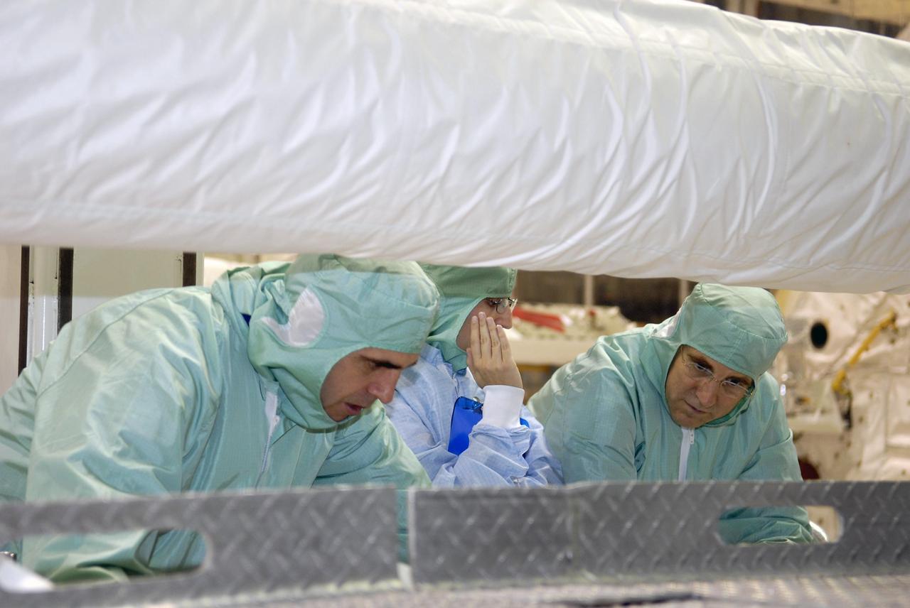 KENNEDY SPACE CENTER, FLA. --   During crew equipment interface test activities at KSC, STS-118 Mission Specialists Richard Mastrocchio (left) and Dr. Dafydd Williams (right) look over the shuttle arm in Endeavour's payload bay. The STS-118 mission will be delivering the third starboard truss segment, the ITS S5, to the International Space Station, as well as the SPACEHAB single cargo module filled with supplies and equipment.  Launch aboard Space Shuttle Endeavour is targeted for Aug. 9.   Photo credit: NASA/Kim Shiflett