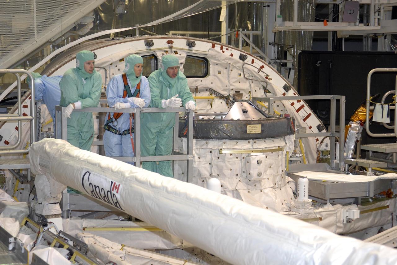 KENNEDY SPACE CENTER, FLA. --   During crew equipment interface test activities at KSC, STS-118 Mission Specialists Tracy Caldwell (center) and  Dr. Dafydd Williams (right) look over the interior of the payload bay of orbiter Endeavour.  The STS-118 mission will be delivering the third starboard truss segment, the ITS S5, to the International Space Station, as well as the SPACEHAB single cargo module filled with supplies and equipment.  Launch aboard Space Shuttle Endeavour is targeted for Aug. 9.   Photo credit: NASA/Kim Shiflett