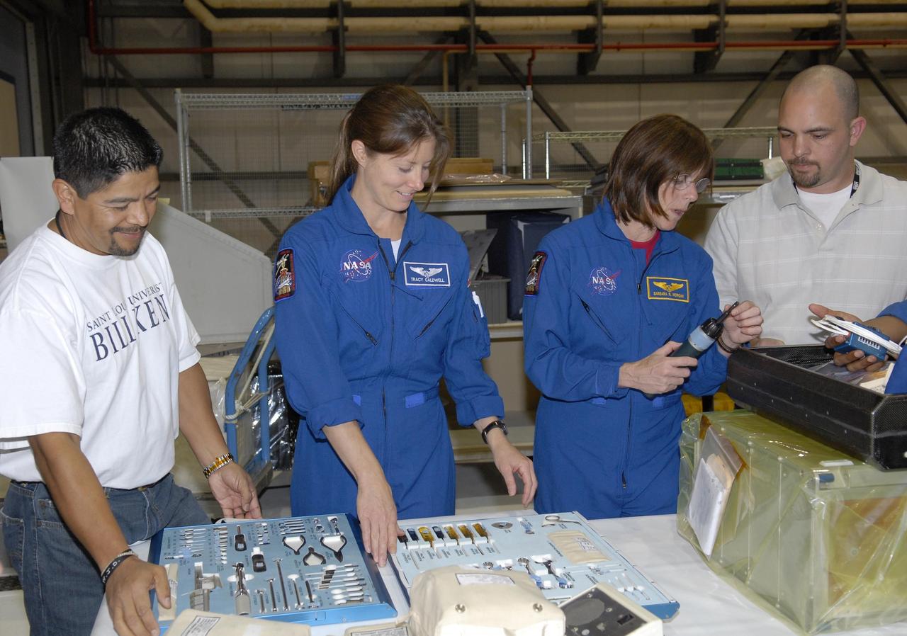KENNEDY SPACE CENTER, FLA. --  During crew equipment interface test activities in Orbiter Processing Facility bay 3 at KSC, STS-118 crew members get a close look at equipment they will use on their flight.  Seen here at center are Mission Specialists Tracy Caldwell and Barbara Morgan.  The STS-118 mission will be delivering the third starboard truss segment, the ITS S5, to the International Space Station, as well as the SPACEHAB single cargo module filled with supplies and equipment.  Launch aboard Space Shuttle Endeavour is targeted for Aug. 9.   Photo credit: NASA/Kim Shiflett