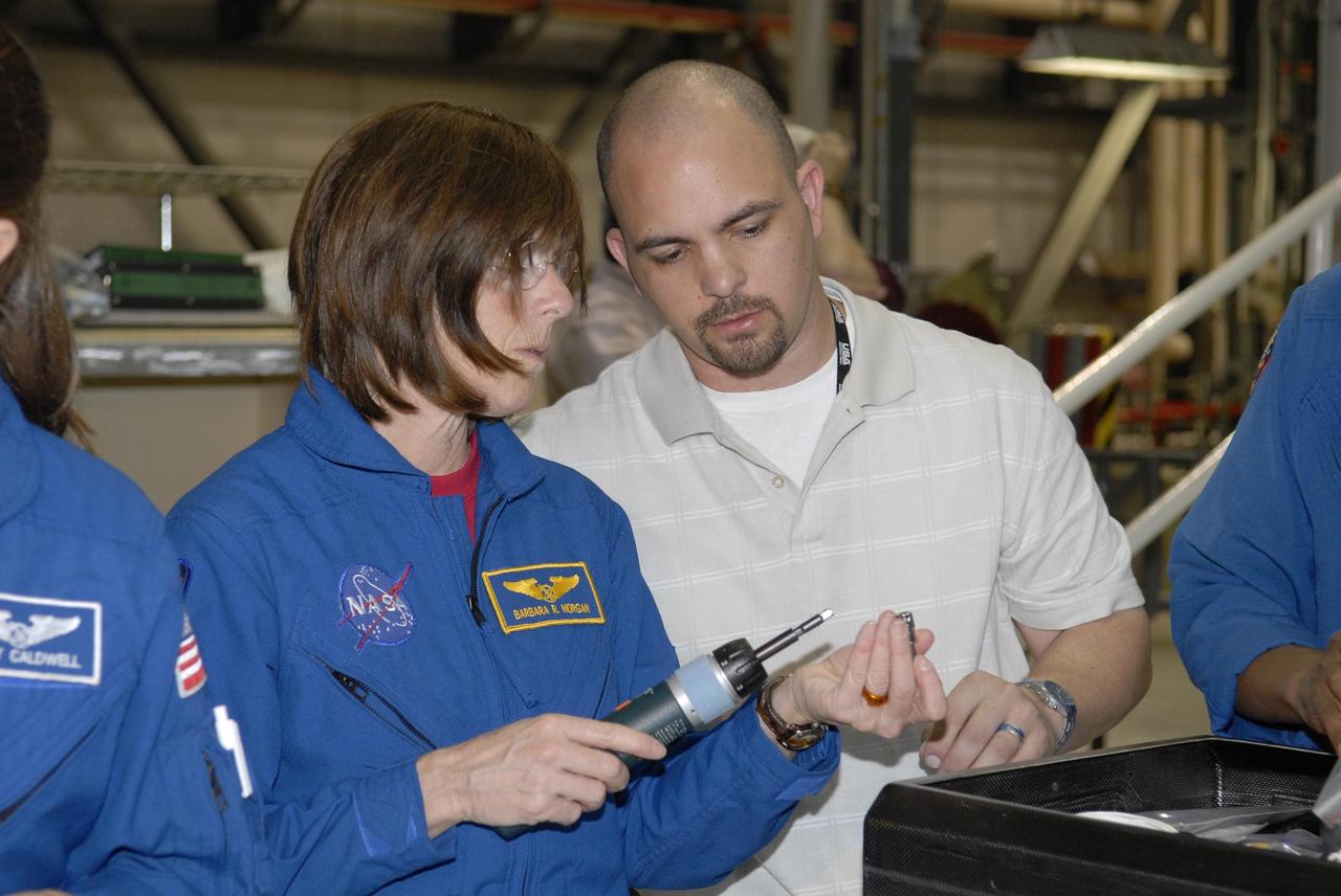 KENNEDY SPACE CENTER, FLA. --  During crew equipment interface test activities in Orbiter Processing Facility bay 3 at KSC, STS-118 Mission Specialist Barbara Morgan gets hands-on practice with tools she may use during the flight. The STS-118 mission will be delivering the third starboard truss segment, the ITS S5, to the International Space Station, as well as the SPACEHAB single cargo module filled with supplies and equipment.  Launch aboard Space Shuttle Endeavour is targeted for Aug. 9.   Photo credit: NASA/Kim Shiflett