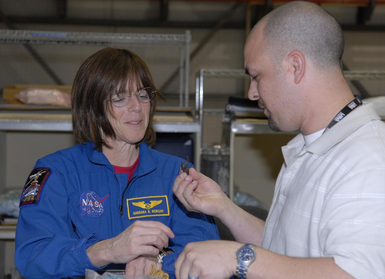 KENNEDY SPACE CENTER, FLA. --   During crew equipment interface test activities in Orbiter Processing Facility bay 3 at KSC, STS-118 Mission Specialist Barbara Morgan learns about a tool that is part of the equipment on the flight. The STS-118 mission will be delivering the third starboard truss segment, the ITS S5, to the International Space Station, as well as the SPACEHAB single cargo module filled with supplies and equipment.  Launch aboard Space Shuttle Endeavour is targeted for Aug. 9.   Photo credit: NASA/Kim Shiflett