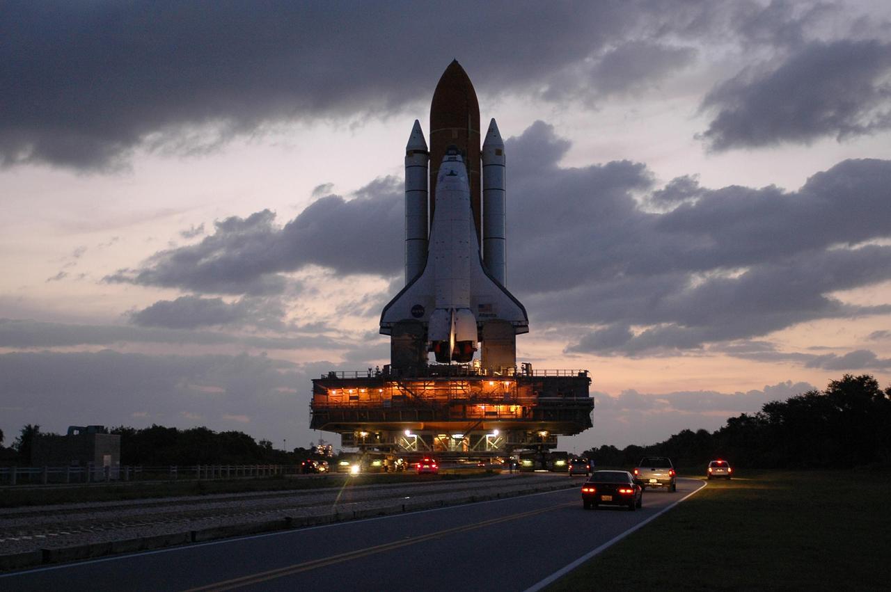 KENNEDY SPACE CENTER, FLA. --  Space Shuttle Atlantis, mounted on a mobile launch platform, rolls to Launch Pad 39A atop a crawler transporter at dawn.  First motion was at 5:02 a.m. EDT.  In late February, Atlantis' external tank received hail damage during a severe thunderstorm that passed through the Kennedy Space Center Launch Complex 39 area. The hail caused visible divots in the giant tank's foam insulation, as well as minor surface damage to about 26 heat shield tiles on the shuttle's left wing. The launch of Space Shuttle Atlantis on mission STS-117 is now targeted for June 8. A flight readiness review will be held on May 30 and 31. Photo credit: NASA/Troy Cryder