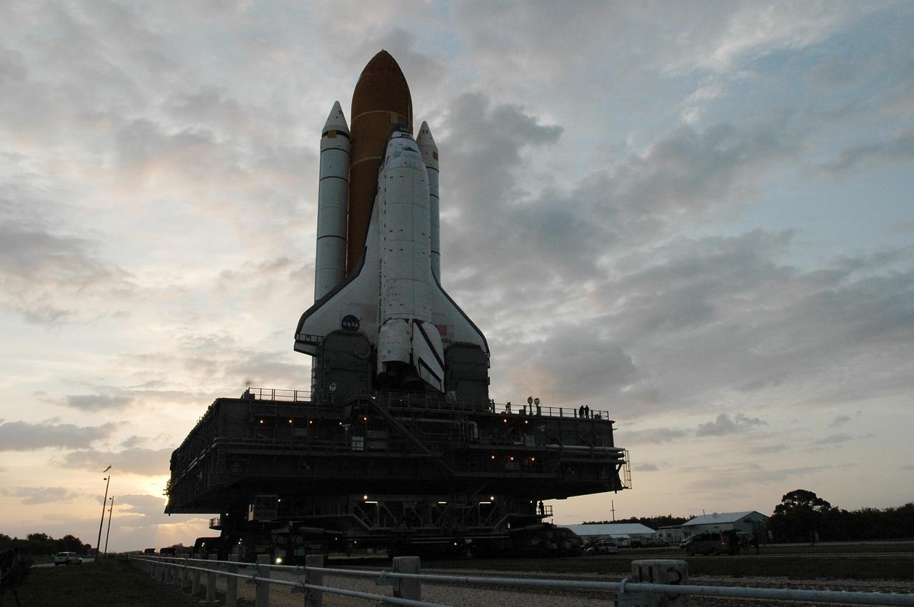 KENNEDY SPACE CENTER, FLA. --  Space Shuttle Atlantis, mounted on a mobile launch platform, rolls to Launch Pad 39A atop a crawler transporter just after sunrise.  First motion was at 5:02 a.m. EDT.  In late February, Atlantis' external tank received hail damage during a severe thunderstorm that passed through the Kennedy Space Center Launch Complex 39 area. The hail caused visible divots in the giant tank's foam insulation, as well as minor surface damage to about 26 heat shield tiles on the shuttle's left wing. The launch of Space Shuttle Atlantis on mission STS-117 is now targeted for June 8. A flight readiness review will be held on May 30 and 31. Photo credit: NASA/Troy Cryder