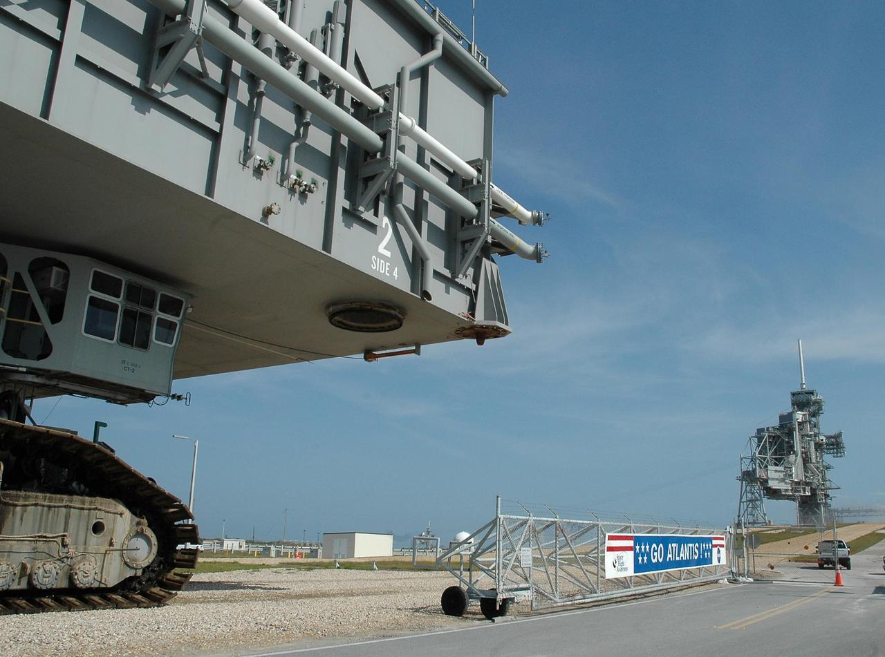 KENNEDY SPACE CENTER, FLA. --  The leading edge of the mobile launch platform atop a crawler transporter, and carrying Space Shuttle Atlantis, heads toward the gate of Launch Pad 39A.  This is the second rollout for the shuttle.  First motion out of the Vehicle Assembly Building was at 5:02 a.m. EDT. In late February, while Atlantis was on the launch pad, Atlantis' external tank received hail damage during a severe thunderstorm that passed through the Kennedy Space Center Launch Complex 39 area. The hail caused visible divots in the giant tank's foam insulation, as well as minor surface damage to about 26 heat shield tiles on the shuttle's left wing. The shuttle was returned to the VAB for repairs. The launch of Space Shuttle Atlantis on mission STS-117 is now targeted for June 8. A flight readiness review will be held on May 30 and 31.  Photo credit: NASA/Troy Cryder