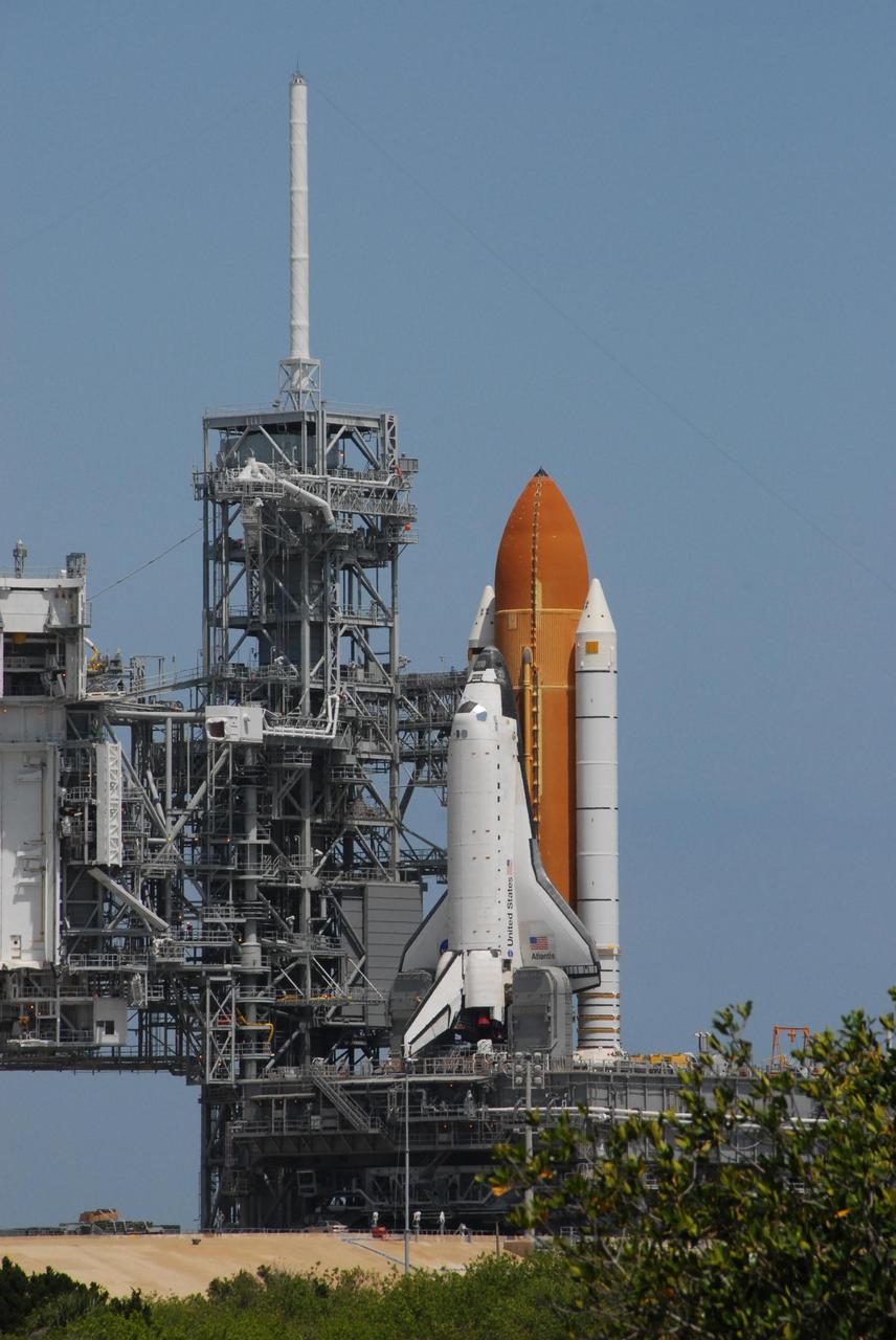 KENNEDY SPACE CENTER, FLA. --   Space Shuttle Atlantis, mounted on a mobile launch platform, finally rests next to the fixed service structure on the hard stand of Launch Pad 39A after an early morning rollout.  Seen at the top of the service structure is the 80-foot-tall lightning mast.  Atlantis rolled out to the pad for the second time before dawn.  First motion out of the Vehicle Assembly Building was at 5:02 a.m. EDT. In late February, while Atlantis was on the launch pad, Atlantis' external tank received hail damage during a severe thunderstorm that passed through the Kennedy Space Center Launch Complex 39 area. The hail caused visible divots in the giant tank's foam insulation, as well as minor surface damage to about 26 heat shield tiles on the shuttle's left wing. The shuttle was returned to the VAB for repairs. The launch of Space Shuttle Atlantis on mission STS-117 is now targeted for June 8. A flight readiness review will be held on May 30 and 31.  Photo credit: NASA/Ken Thornsley