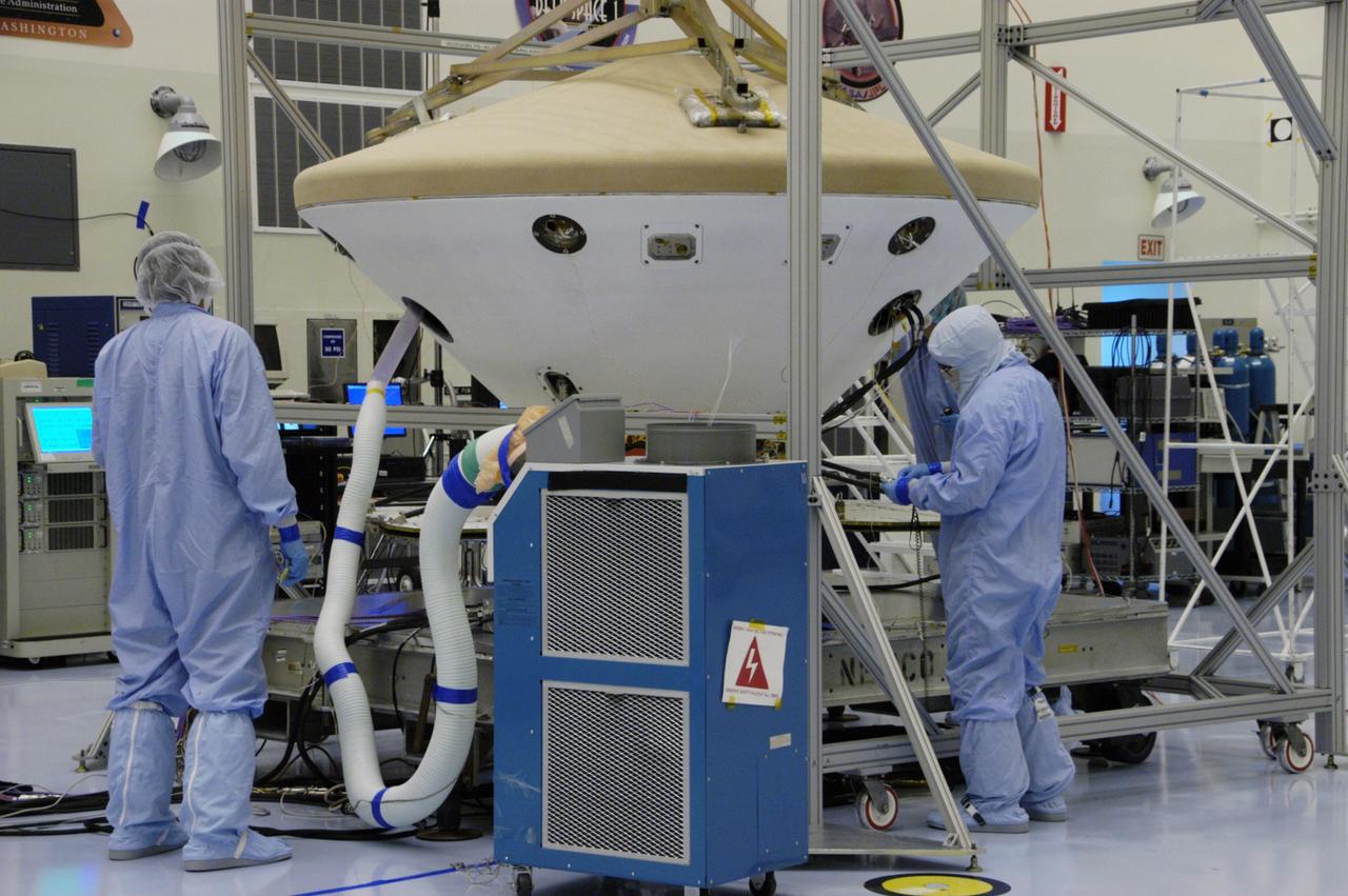 KENNEDY SPACE CENTER, FLA. -- In the Payload Hazardous Servicing Facility, workers monitor the Phoenix spacecraft during a heat shield deployment test, with a firing of ordnance associated with the separation device. Phoenix will land in icy soils near the north polar permanent ice cap of Mars and explore the history of the water in these soils and any associated rocks, while monitoring polar climate. Landing is planned in May 2008 on arctic ground where a mission currently in orbit, Mars Odyssey, has detected high concentrations of ice just beneath the top layer of soil. Launch of Phoenix aboard a Delta II rocket is targeted for Aug. 3 from Cape Canaveral Air Force Station in Florida. Photo credit: NASA/George Shelton