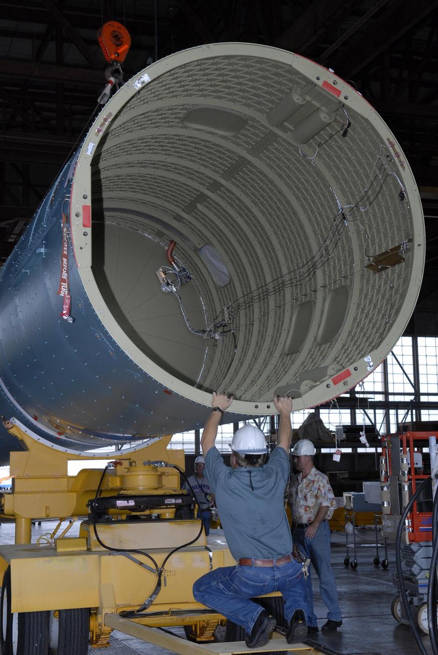KENNEDY SPACE CENTER, FLA. --   Inside the Hangar M on Cape Canaveral Air Force Station, United Launch Alliance workers help guide the Delta II first stage onto its transporter.  The Delta will be moved to the launch pad for the future launch of a Global Positioning Satellite.  Photo credit: NASA/Kim Shiflett