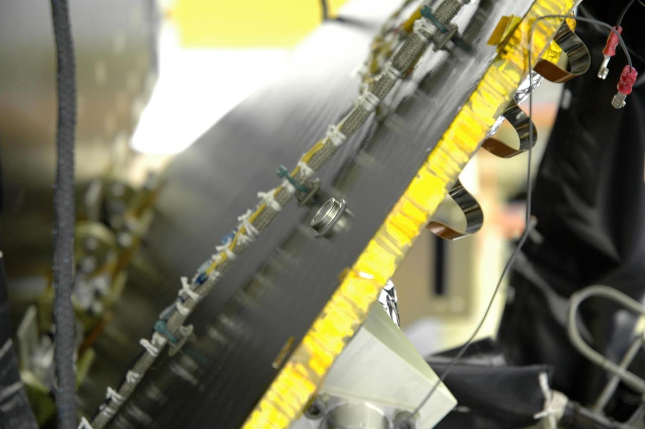 KENNEDY SPACE CENTER, FLA. -- In the Astrotech Space Operations facility, a computer chip is bonded to a side brace on the Dawn spacecraft. The silicon chip holds the names of more than 360,000 space enthusiasts worldwide who signed up to participate in a virtual voyage to the asteroid belt and is about the size of an American five-cent coin. Dawn's mission is to explore two of the asteroid belt's most intriguing and dissimilar occupants: asteroid Vesta and the dwarf planet Ceres. Dawn is scheduled to launch June 30 from Launch Complex 17-B. Photo credit: NASA/Jim Grossmann