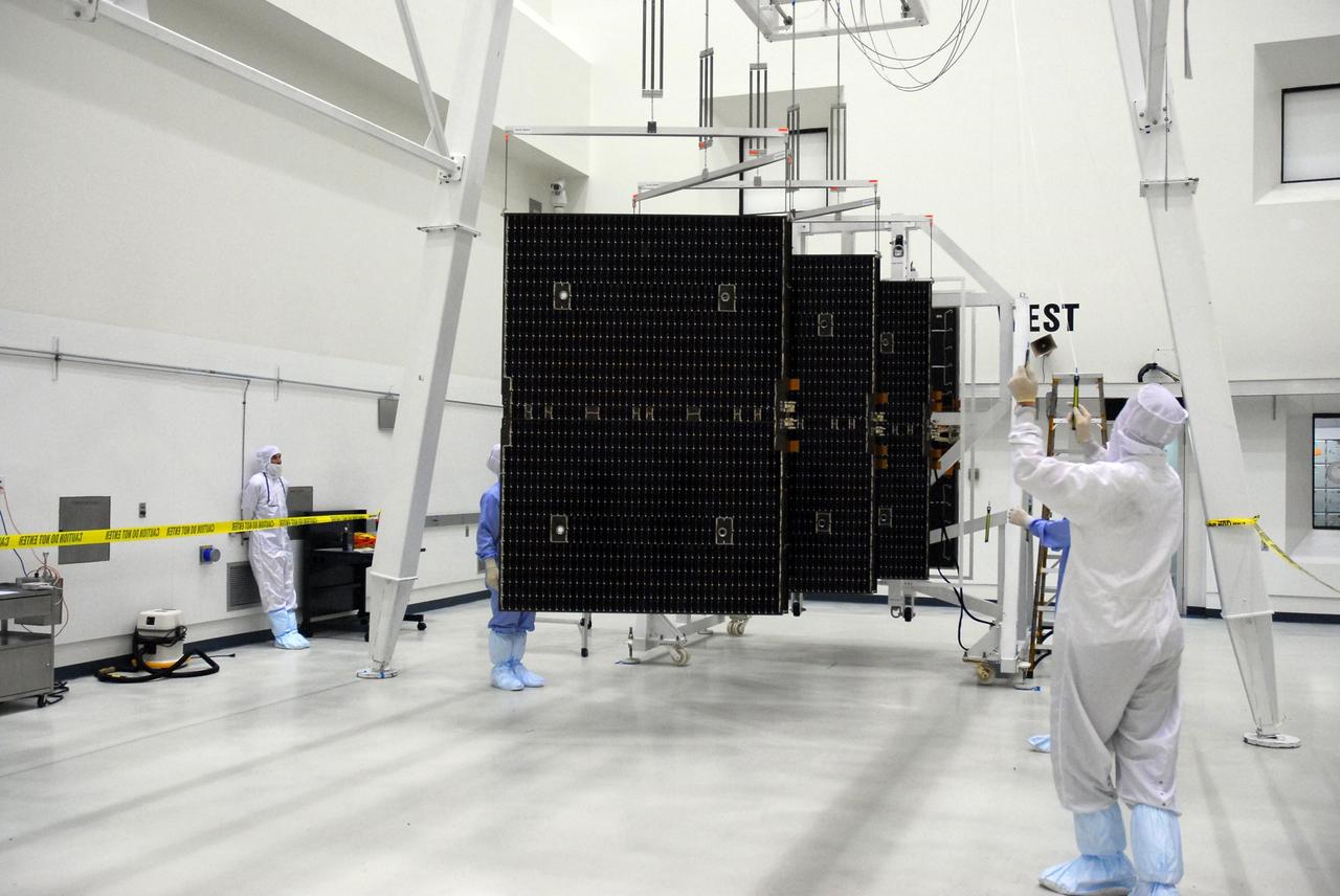 KENNEDY SPACE CENTER, FLA. --   In a clean room at Astrotech, workers deploy the solar panels of the Dawn spacecraft.  The panels will be tested and undergo black light inspection.  Dawn's mission is to explore two of the asteroid belt's most intriguing and dissimilar occupants: asteroid Vesta and the dwarf planet Ceres.  Dawn is scheduled to launch June 30 from Launch Complex 17-B.    Photo credit: NASA/George Shelton