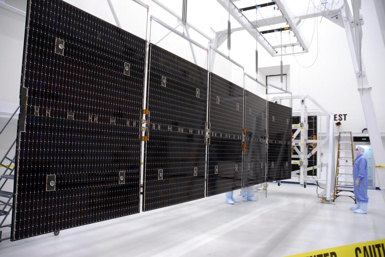 KENNEDY SPACE CENTER, FLA. --   In a clean room at Astrotech, the solar panels of the Dawn spacecraft are extended to their full extent.  The panels will be tested and undergo black light inspection. Dawn's mission is to explore two of the asteroid belt's most intriguing and dissimilar occupants: asteroid Vesta and the dwarf planet Ceres.  Dawn is scheduled to launch June 30 from Launch Complex 17-B.  Photo credit: NASA/George Shelton