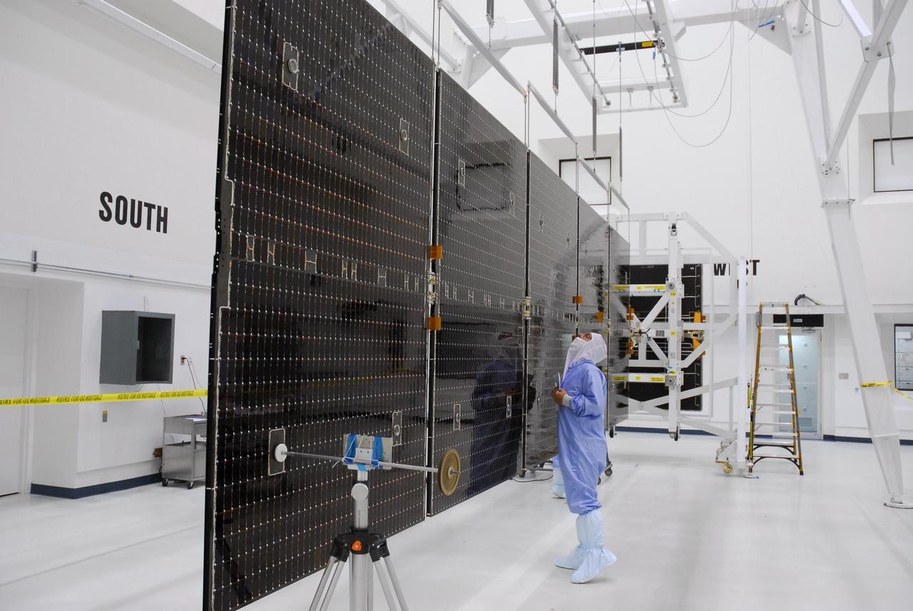 KENNEDY SPACE CENTER, FLA. --   In a clean room at Astrotech, workers begin checking the solar panels of the Dawn spacecraft.  The panels will also undergo black light inspection. Dawn's mission is to explore two of the asteroid belt's most intriguing and dissimilar occupants: asteroid Vesta and the dwarf planet Ceres.  Dawn is scheduled to launch June 30 from Launch Complex 17-B.  Photo credit: NASA/George Shelton