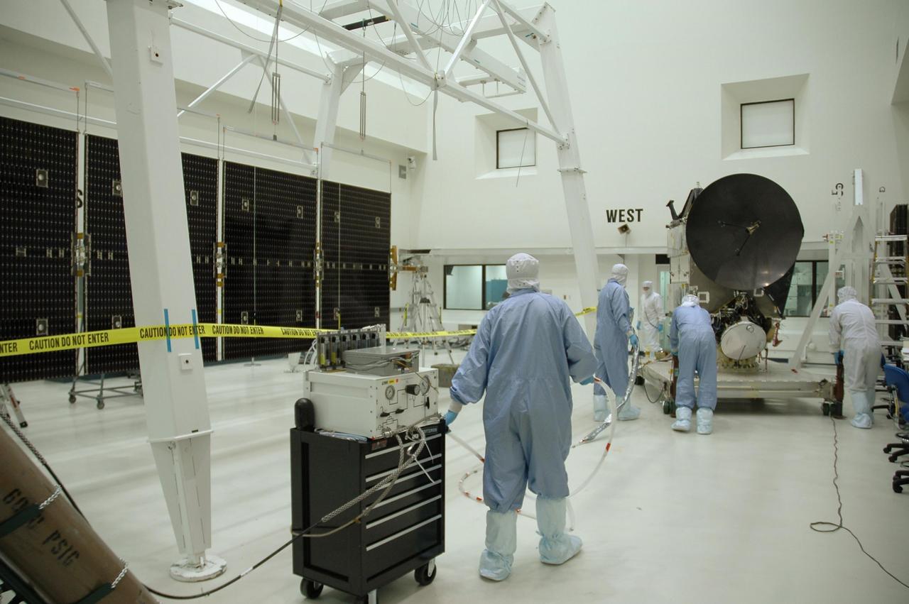 KENNEDY SPACE CENTER, FLA. -- In another clean room at Astrotech, solar array panels are lined up at left to be installed on the Dawn spacecraft, at right. Dawn's mission is to explore two of the asteroid belt's most intriguing and dissimilar occupants: asteroid Vesta and the dwarf planet Ceres.  Dawn is scheduled to launch June 30 aboard a Delta II rocket from Launch Complex 17-B at Cape Canaveral Air Force Station.    Photo credit: NASA/Jack Pfaller