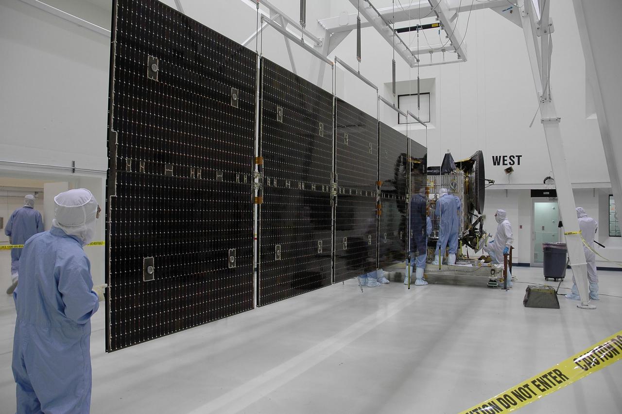 KENNEDY SPACE CENTER, FLA. -- In a clean room at Astrotech, the solar array panels at left are being installed on the Dawn spacecraft, in the background. Dawn's mission is to explore two of the asteroid belt's most intriguing and dissimilar occupants: asteroid Vesta and the dwarf planet Ceres.  Dawn is scheduled to launch June 30 aboard a Delta II rocket from Launch Complex 17-B at Cape Canaveral Air Force Station.    Photo credit: NASA/Jack Pfaller